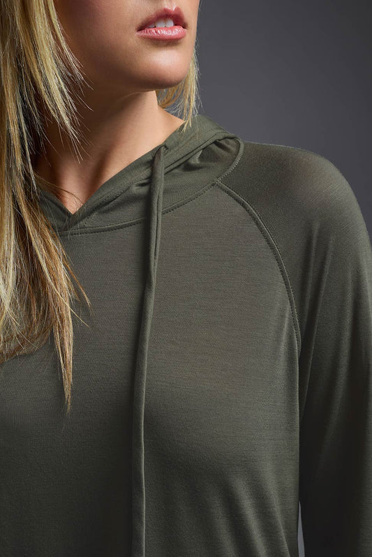 A female model wearing the women's Siro™ Hoodie Shirt in the color olive, made out of 100% filament polyester, showing the relaxed fit from a cropped collar closeup front view. This long sleeve hoodie shirt is breathable, quick-drying, moisture-wicking, and made in the USA. #olive