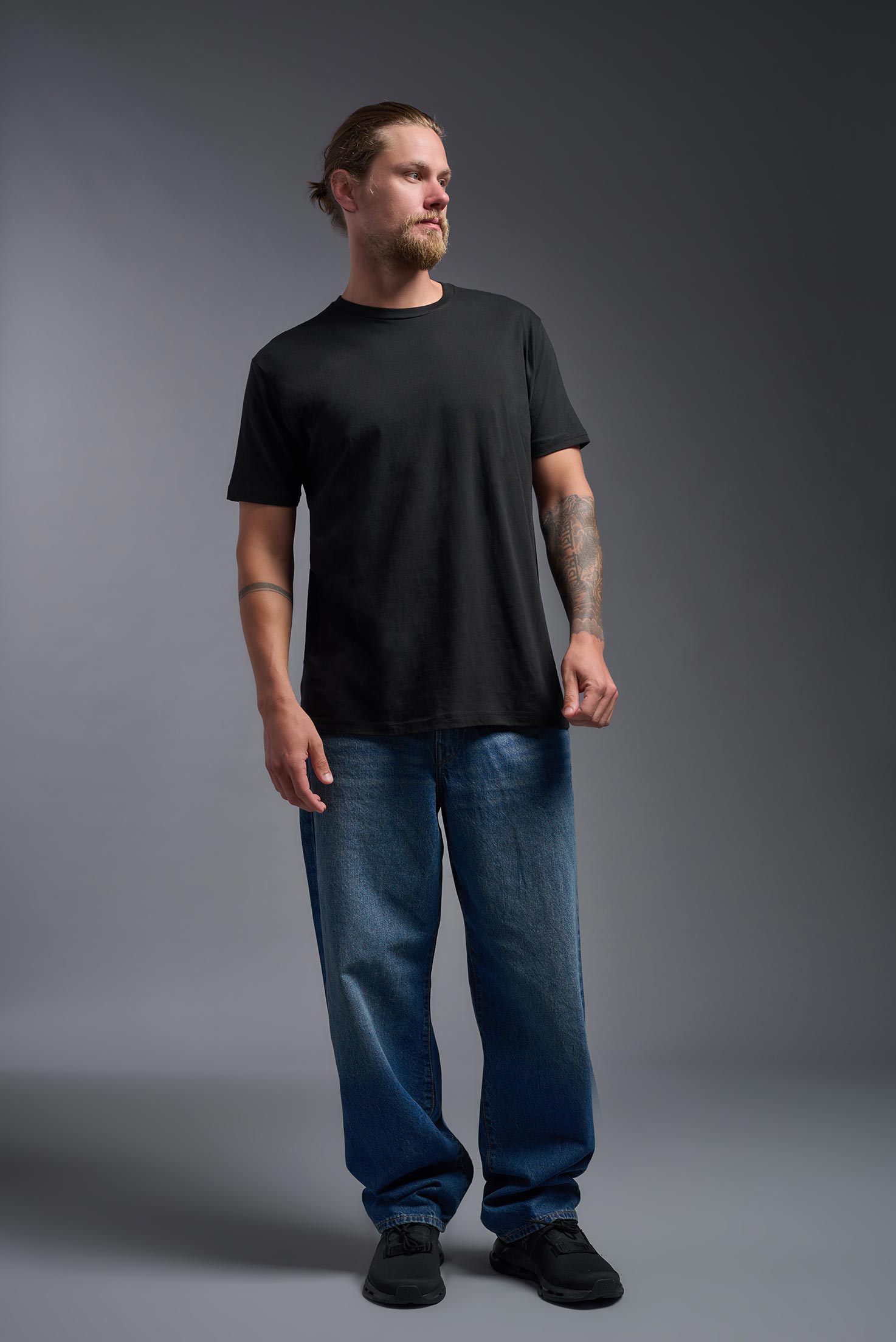 A male model wearing the unisex Americana Cotton Soft Tee in the color black, made from 100% combed ring-spun USA-grown cotton, showing the classic fit from a front view. This premium shirt is Made in the USA. #black