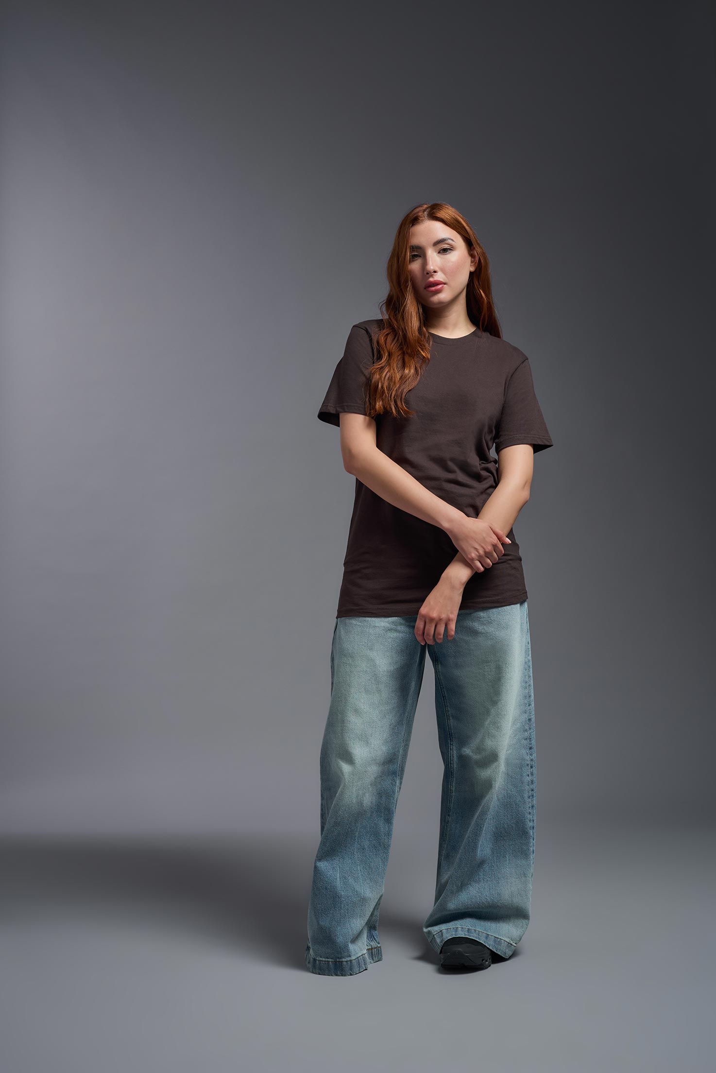 A female model wearing the unisex Americana Cotton Soft Tee in the color brown, made from 100% combed ring-spun USA-grown cotton, showing the classic fit from a front view. This premium shirt is Made in the USA. #brown