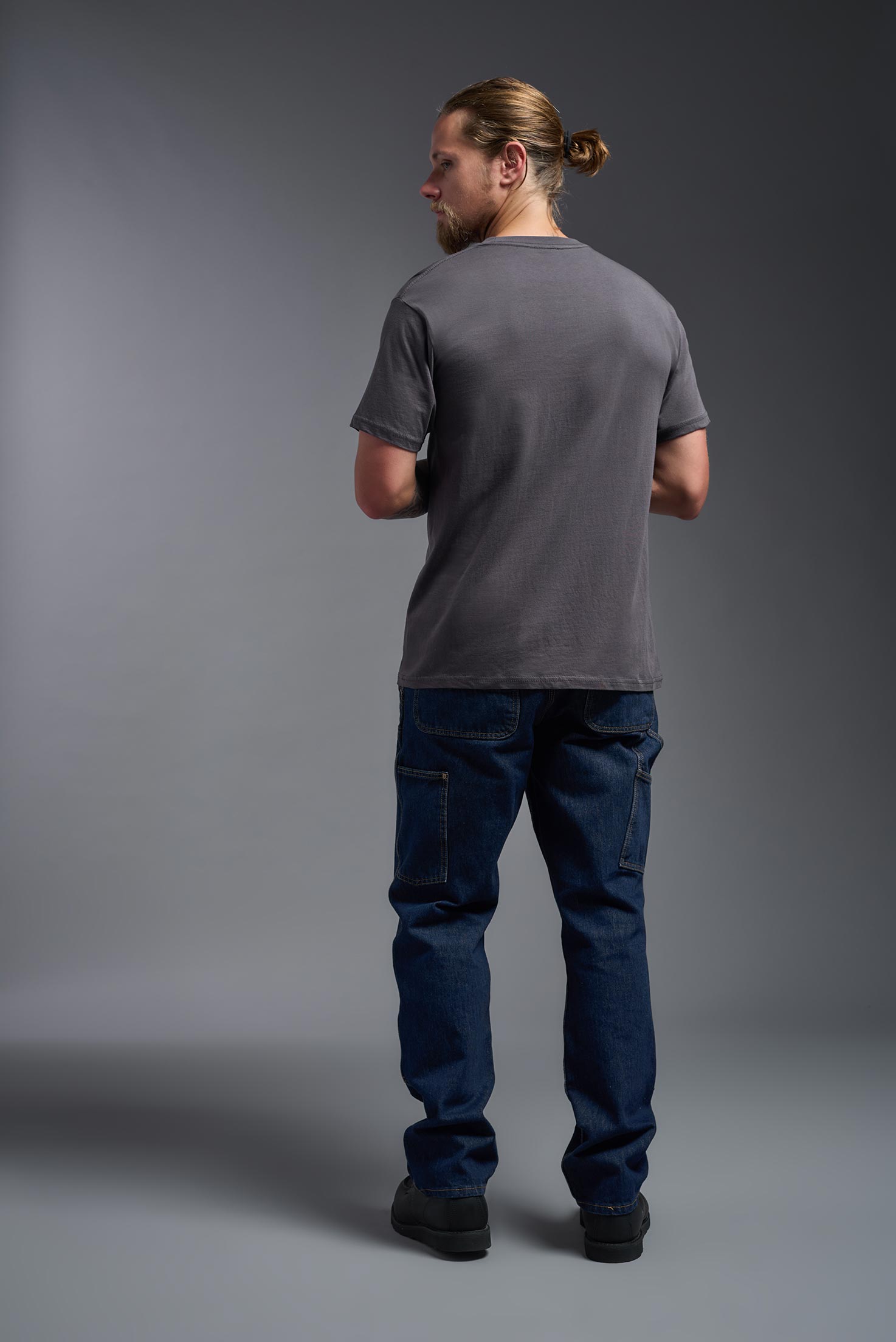 A male model wearing the unisex Americana Cotton Soft Tee in the color charcoal, made from 100% combed ring-spun USA-grown cotton, showing the classic fit from a back view. This premium shirt is Made in the USA. #charcoal