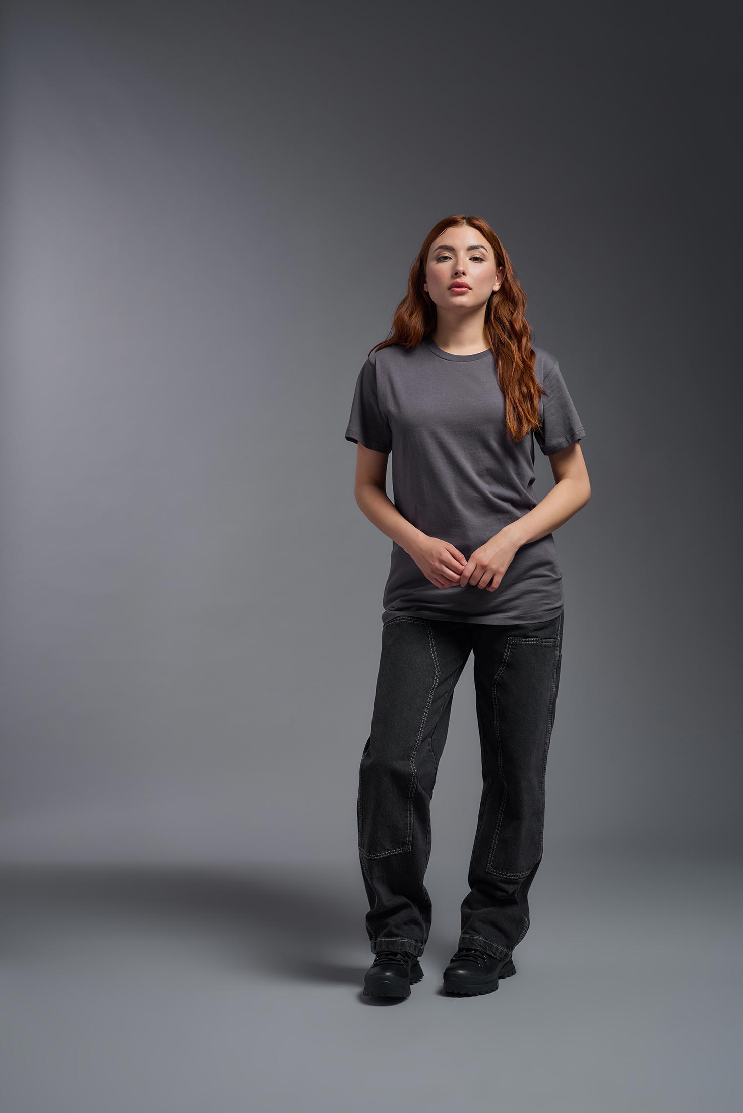 A female model wearing the unisex Americana Cotton Soft Tee in the color charcoal, made from 100% combed ring-spun USA-grown cotton, showing the classic fit from a close-up collar view. This premium shirt is Made in the USA. #charcoal