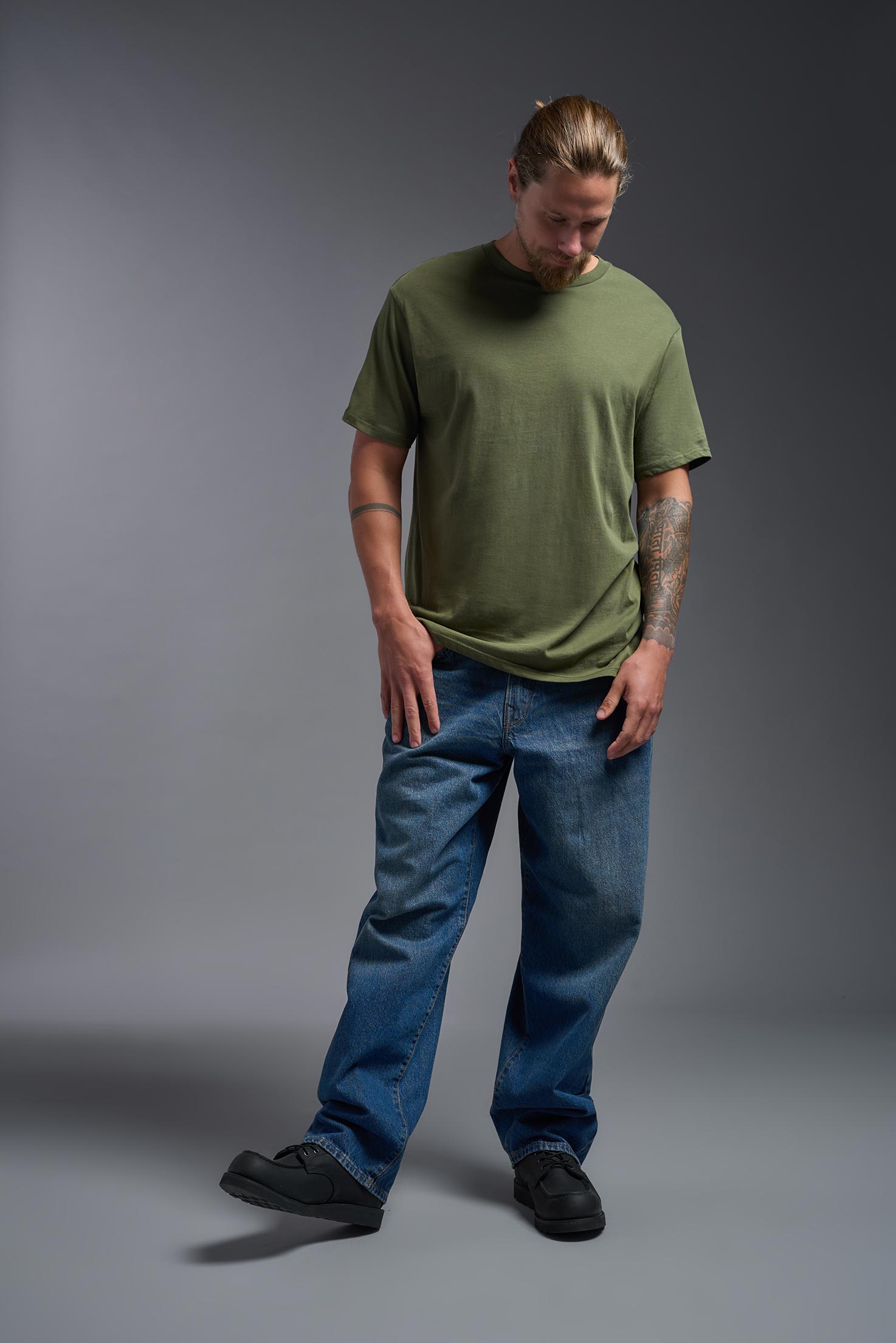 A male model wearing the unisex Americana Cotton Soft Tee in the color military green, made from 100% combed ring-spun USA-grown cotton, showing the classic fit from a front view. This premium shirt is Made in the USA. #military-green