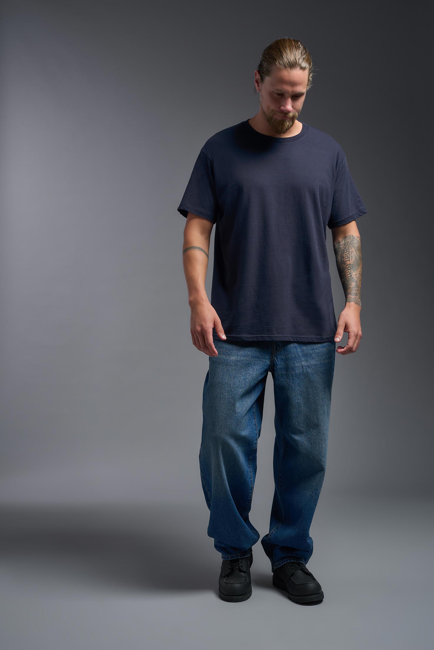 A male model wearing the unisex Americana Cotton Soft Tee in the color navy, made from 100% combed ring-spun USA-grown cotton, showing the classic fit from a front view. This premium shirt is Made in the USA. #navy