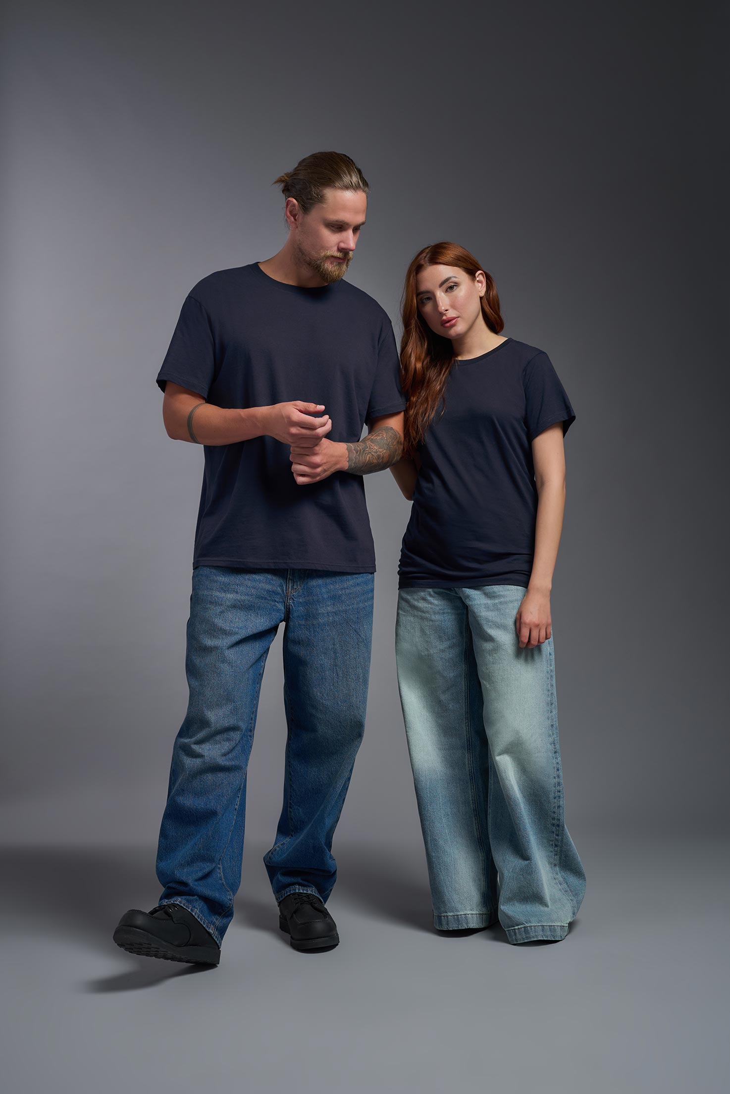 A male and female model wearing the unisex Americana Cotton Soft Tee in the color navy, made from 100% combed ring-spun USA-grown cotton, showing the classic fit from a front view. This premium shirt is Made in the USA. #navy