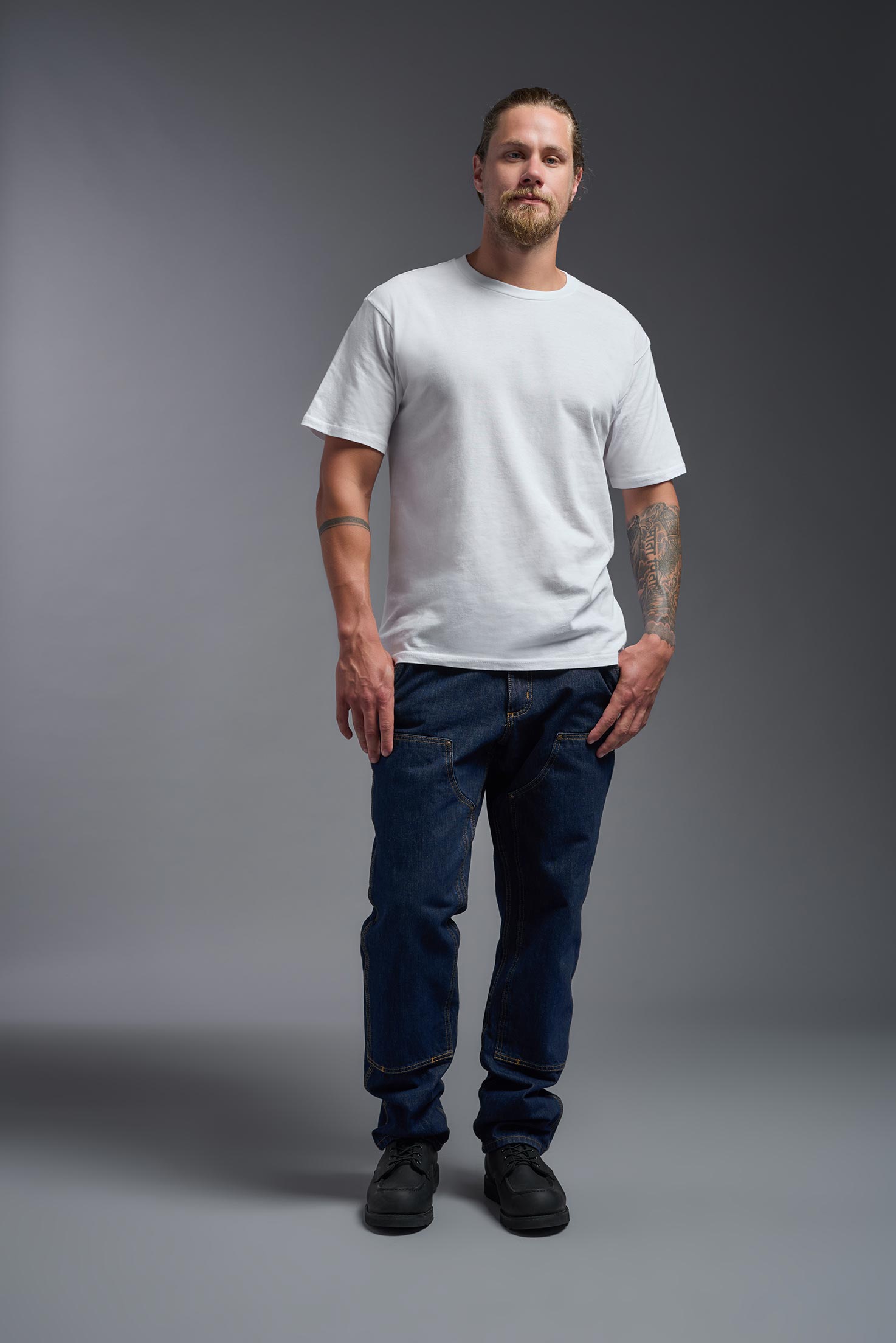 A male model wearing the unisex Americana Cotton Soft Tee in the color white, made from 100% combed ring-spun USA-grown cotton, showing the classic fit from a front view. This premium shirt is Made in the USA. #white