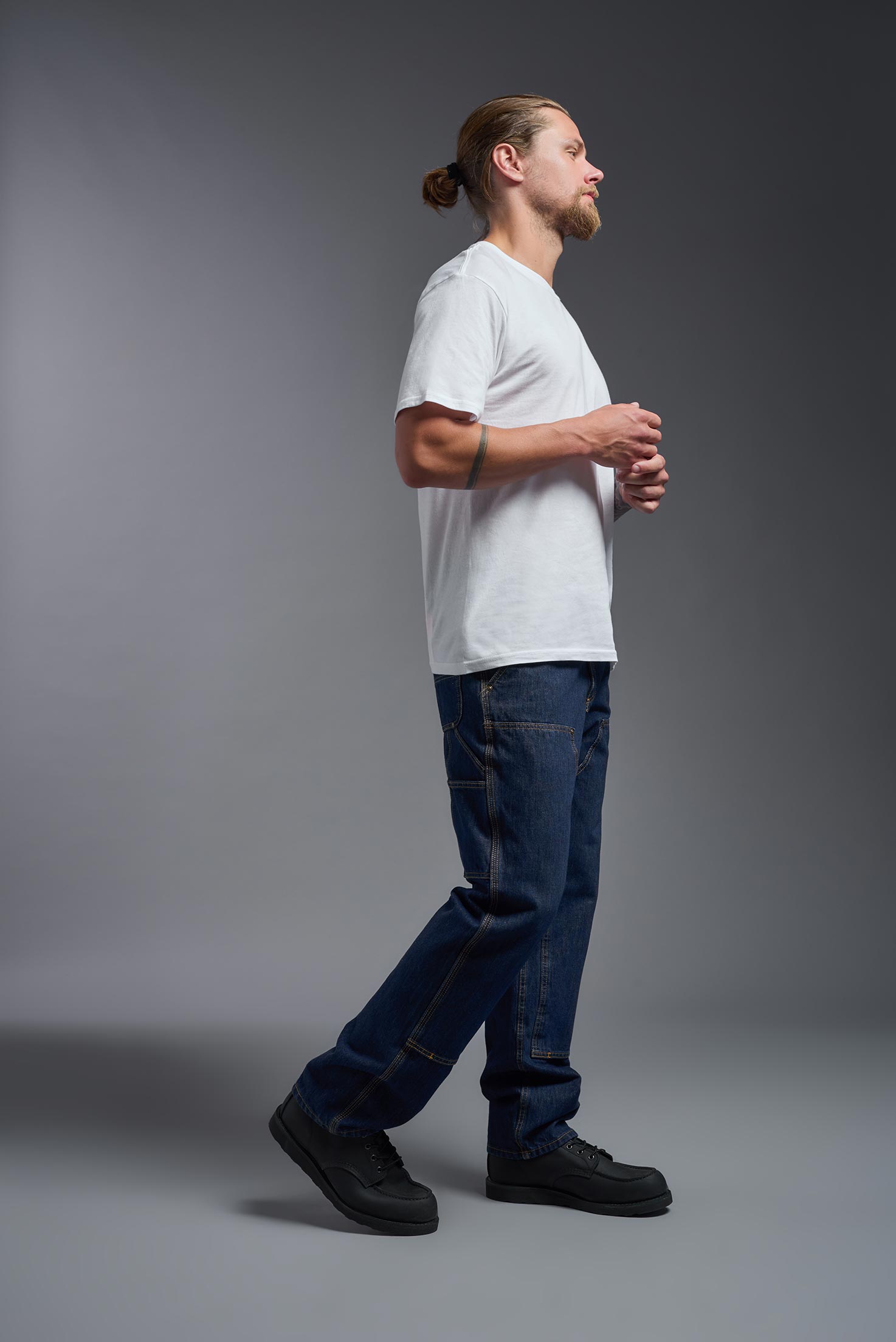 A male model wearing the unisex Americana Cotton Soft Tee in the color white, made from 100% combed ring-spun USA-grown cotton, showing the classic fit from a side view. This premium shirt is Made in the USA. #white