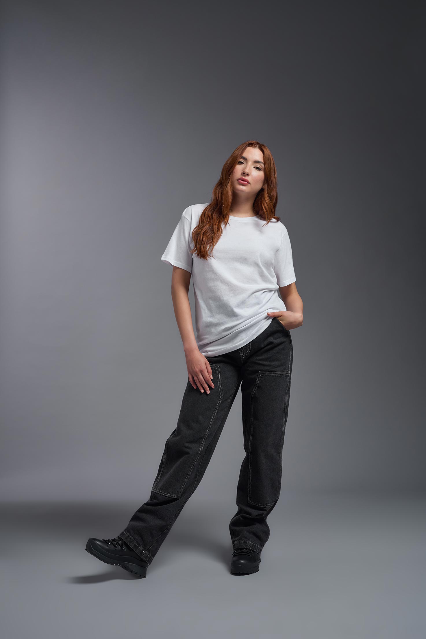 A female model wearing the unisex Americana Cotton Soft Tee in the color white, made from 100% combed ring-spun USA-grown cotton, showing the classic fit from a back view. This premium shirt is Made in the USA. #white