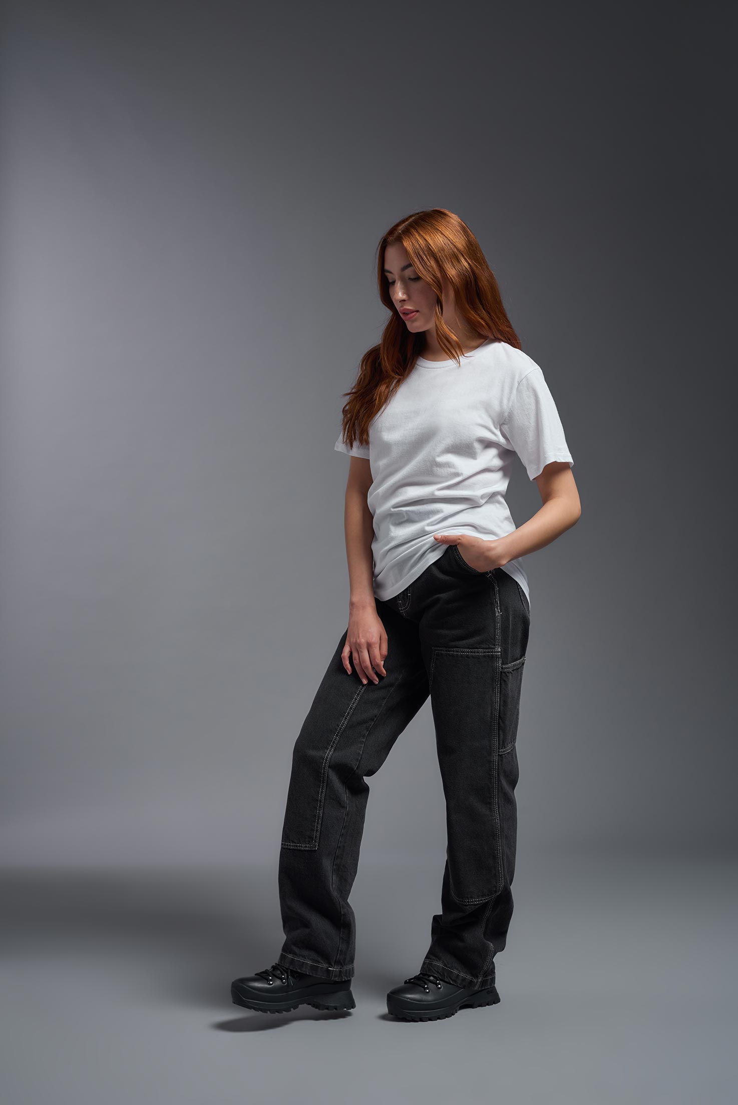 A female model wearing the unisex Americana Cotton Soft Tee in the color white, made from 100% combed ring-spun USA-grown cotton, showing the classic fit from a side view. This premium shirt is Made in the USA. #white