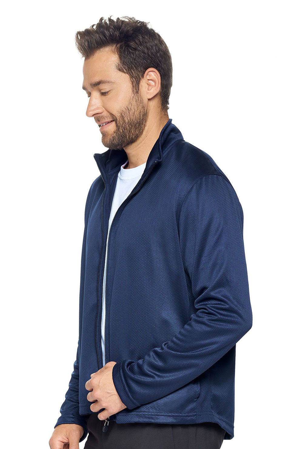 A male model on a white background wearing the men's Sphere Sportsman Jacket in the color navy made out of 100% polyester showing the relaxed fit from a side view. This jacket quick-dries, wicks moisture and is made in the USA. #navy