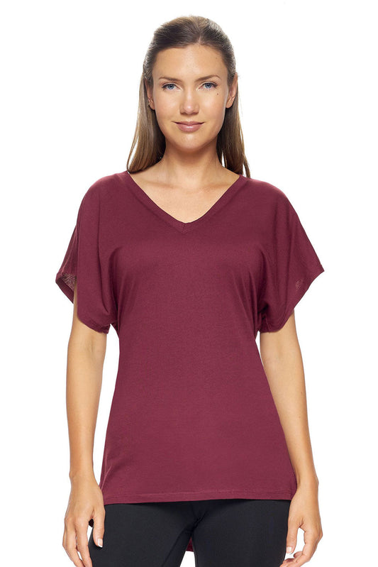 A female model with brown hair wearing the Women's MoCA V-Neck Cinch Tee in the color maroon, made from a luxurious blend of 50% LENZING Modal and 50% Combed Ring-Spun Cotton, showing the relaxed fit from a front view. This fashion-forward, more sustainable t-shirt is elevated, eco-friendly, made in the USA, and available for bulk purchase. #maroon