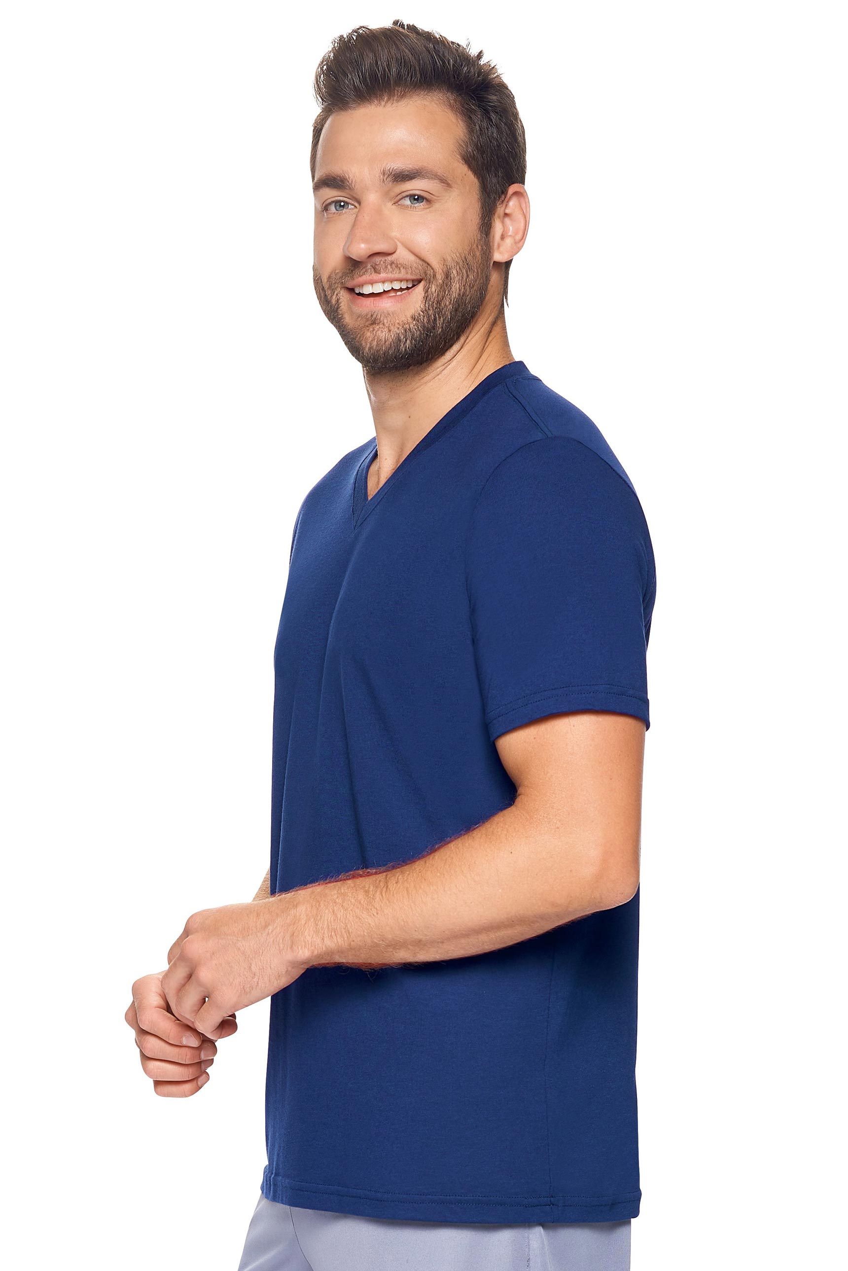 A male model with curly hair wearing the Men's MoCA V-Neck Tee in the color navy, made from a luxurious blend of 50% LENZING Modal and 50% Combed Ring-Spun Cotton, showing the relaxed fit from a side view. This fashion-forward, more sustainable t-shirt is elevated, eco-friendly, made in the USA, and available for bulk purchase. #navy