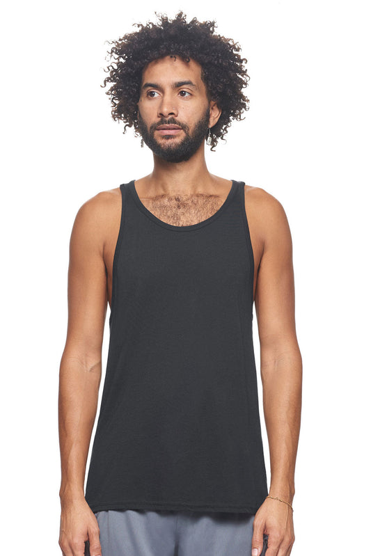 A male model with curly hair wearing the men's MoCA Sleeveless Tank in the color black, made from a luxurious blend of 50% LENZING Modal and 50% Combed Ring-Spun Cotton, showing the relaxed fit from a front view. This tank is elevated, eco-friendly, made in the USA, and available for bulk purchase. #black