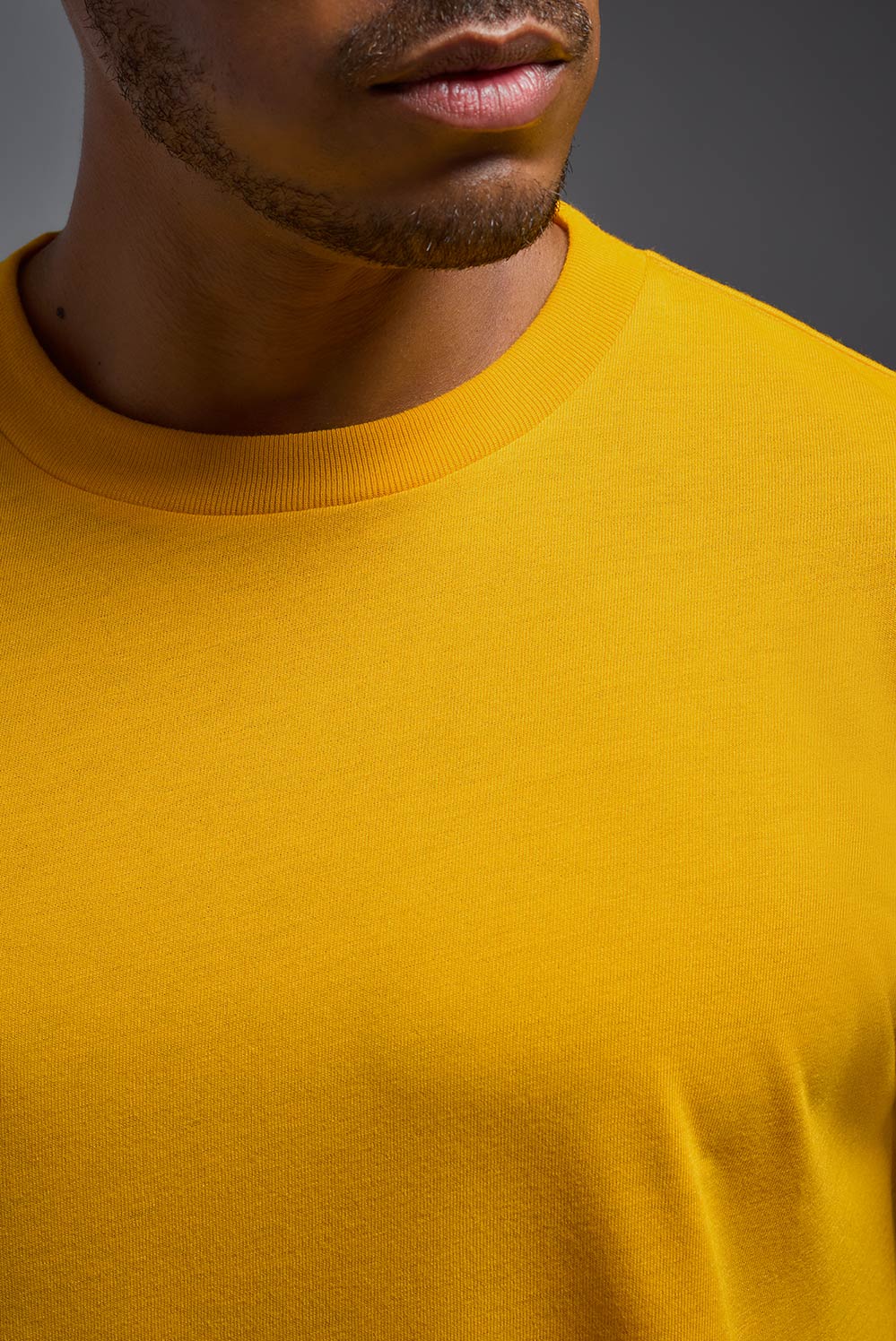 A male model wearing the men's DuroSoft Outdoor Tee in army yellow, made out of 100% filament polyester, showing the modern fit from a closeup collar view. This shirt quick-dries, wicks moisture and is made in the USA. #army-yellow