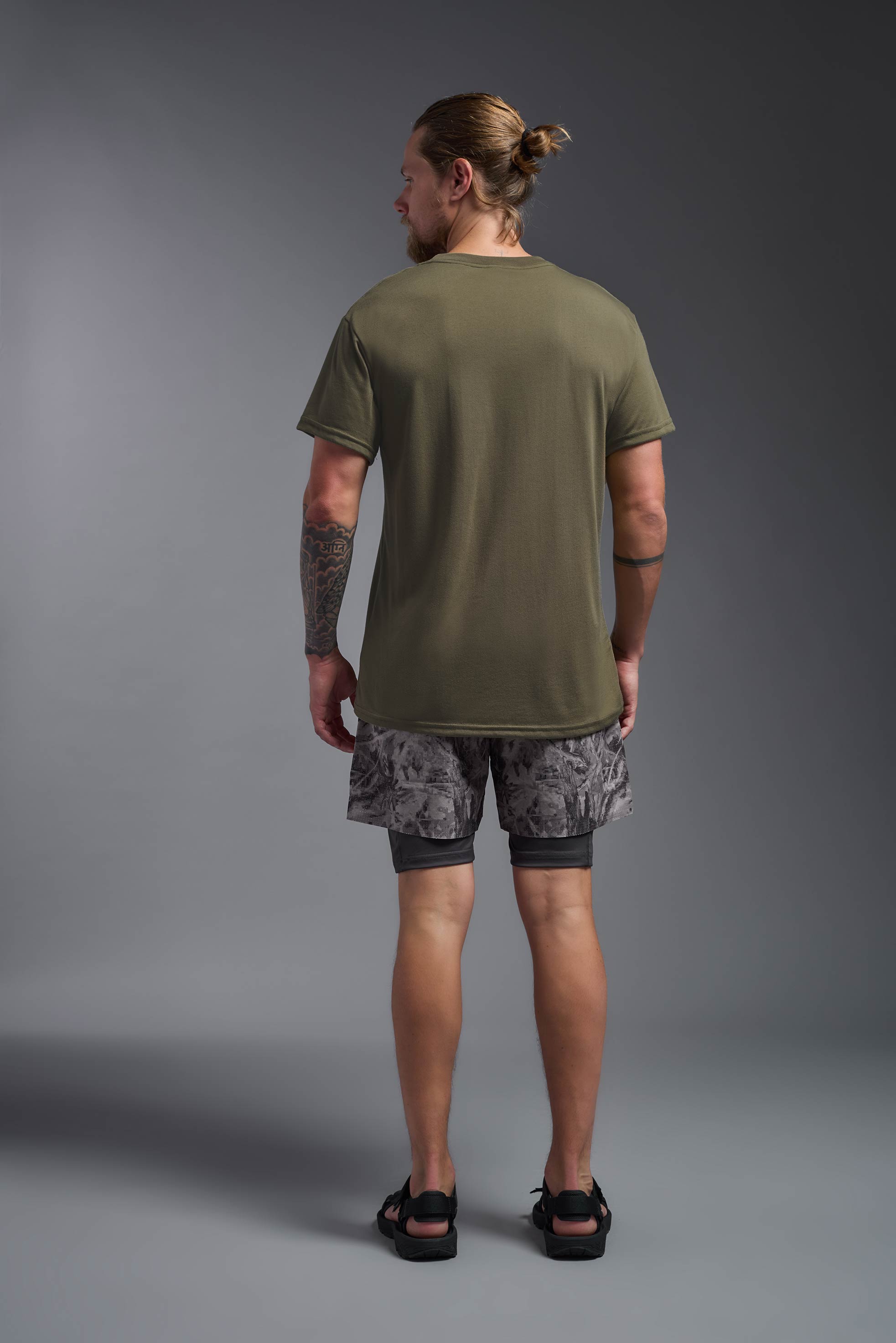 A male model wearing the men's DuroSoft Outdoor Tee in the color tan, made out of 100% filament polyester, showing the modern fit from a back view. This shirt quick-dries, wicks moisture and is made in the USA. #tan-499