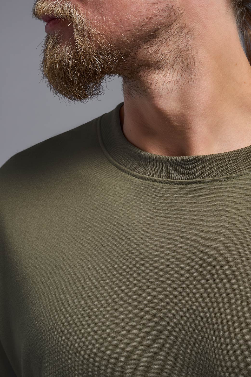 A male model wearing the men's DuroSoft Outdoor Tee in the color tan, made out of 100% filament polyester, showing the modern fit from a closeup collar front view. This shirt quick-dries, wicks moisture and is made in the USA. #tan-499