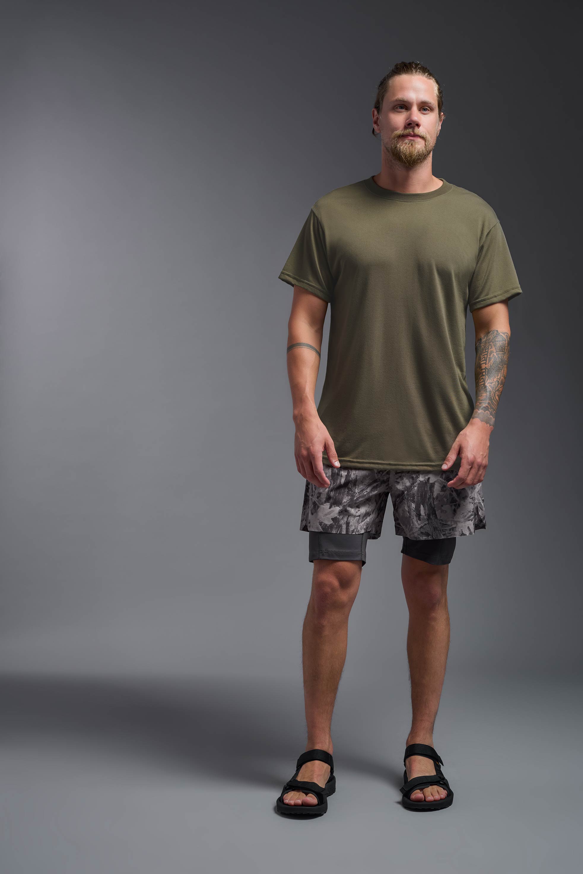 A male model wearing the men's DuroSoft Outdoor Tee in the color tan, made out of 100% filament polyester, showing the modern fit from a front view. This shirt quick-dries, wicks moisture and is made in the USA. #tan-499