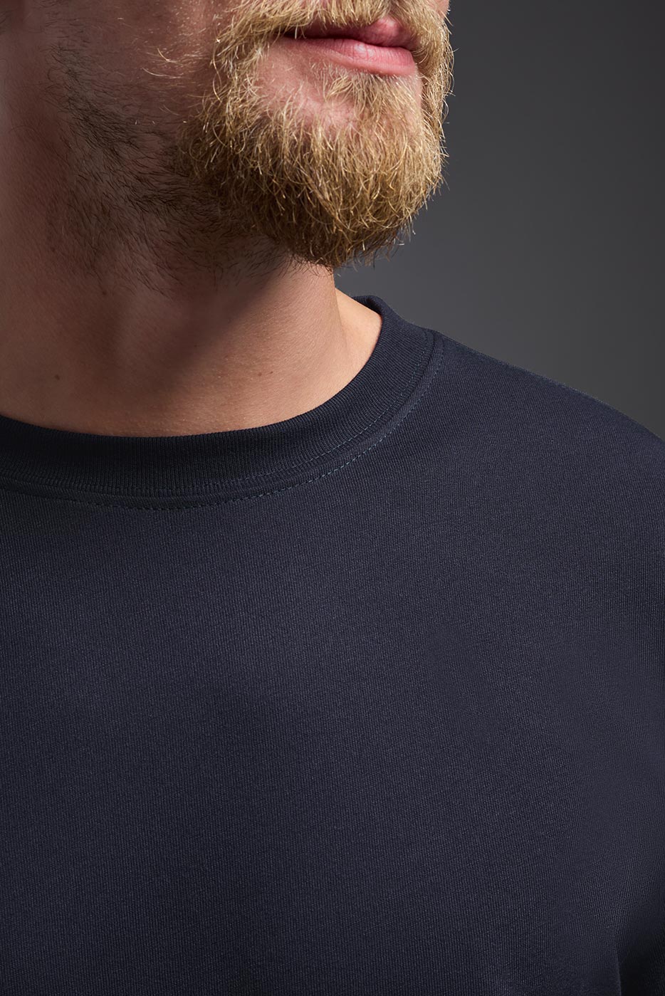 A male model wearing the men's DuroSoft Outdoor Tee in the color army blue, made out of 100% filament polyester, showing the modern fit from a front closeup collar view. This shirt quick-dries, wicks moisture and is made in the USA. #army-blue