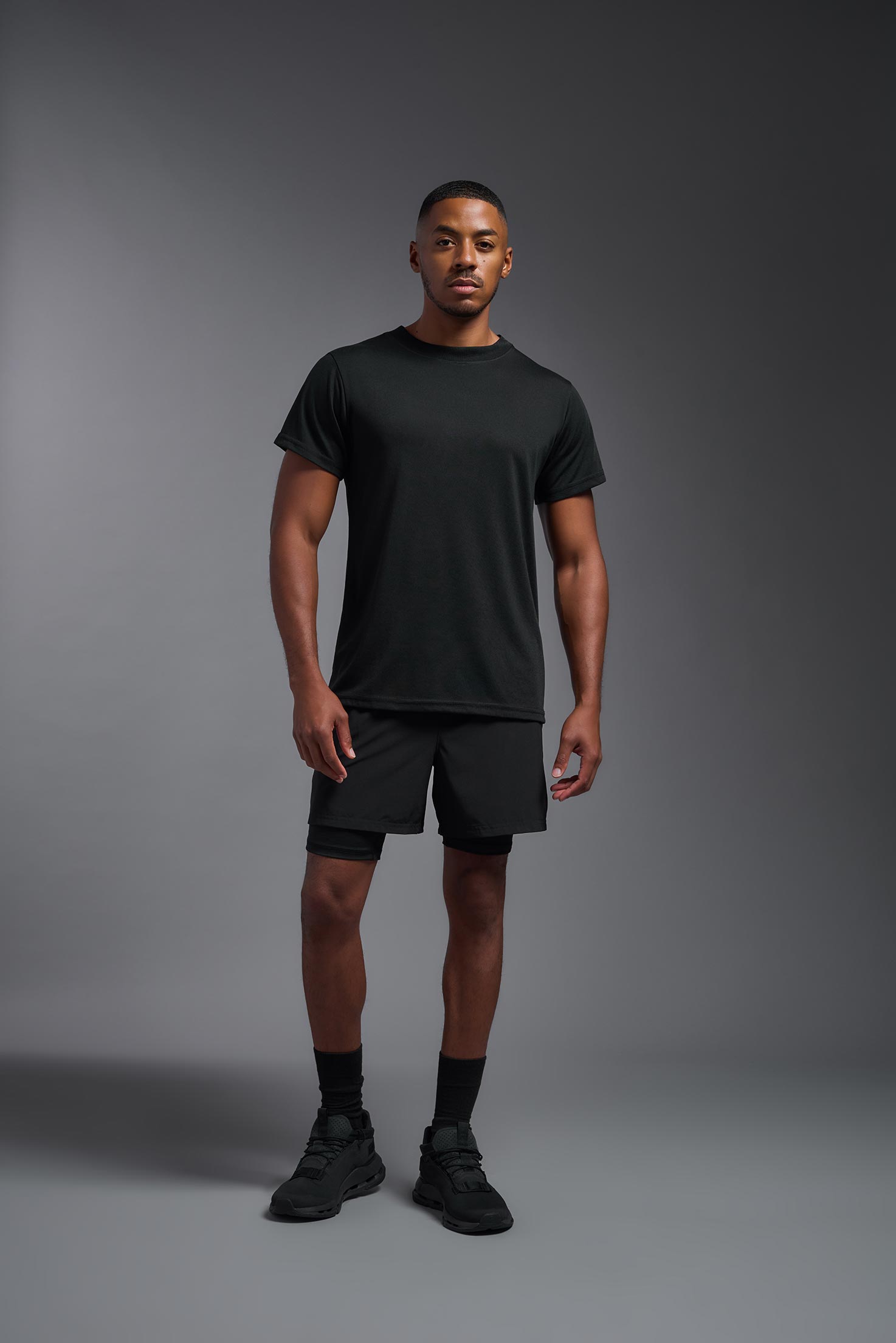 A male model wearing the men's DuroSoft Outdoor Tee in black, made out of 100% filament polyester, showing the modern fit from a front view. This shirt quick-dries, wicks moisture and is made in the USA. #black