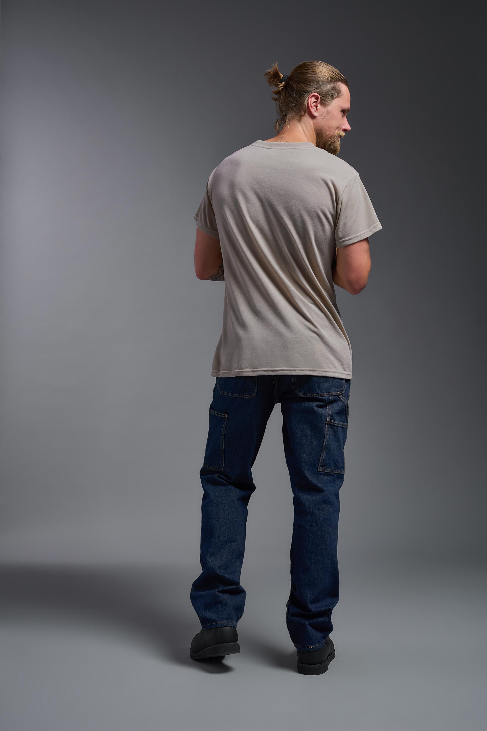 A male model wearing the men's DuroSoft Outdoor Tee in the color desert, made out of 100% filament polyester, showing the modern fit from a back view. This shirt quick-dries, wicks moisture and is made in the USA. #desert