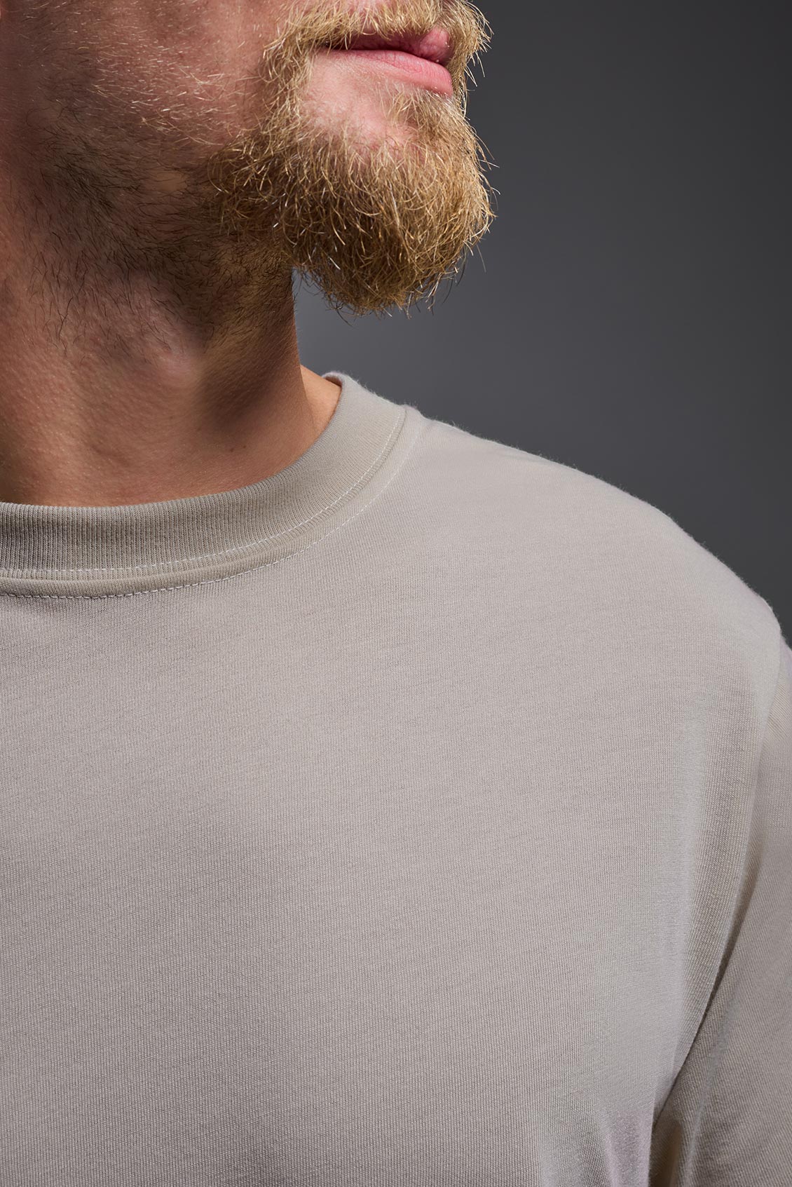 A male model wearing the men's DuroSoft Outdoor Tee in the color desert, made out of 100% filament polyester, showing the modern fit from a closeup collar view. This shirt quick-dries, wicks moisture and is made in the USA. #desert