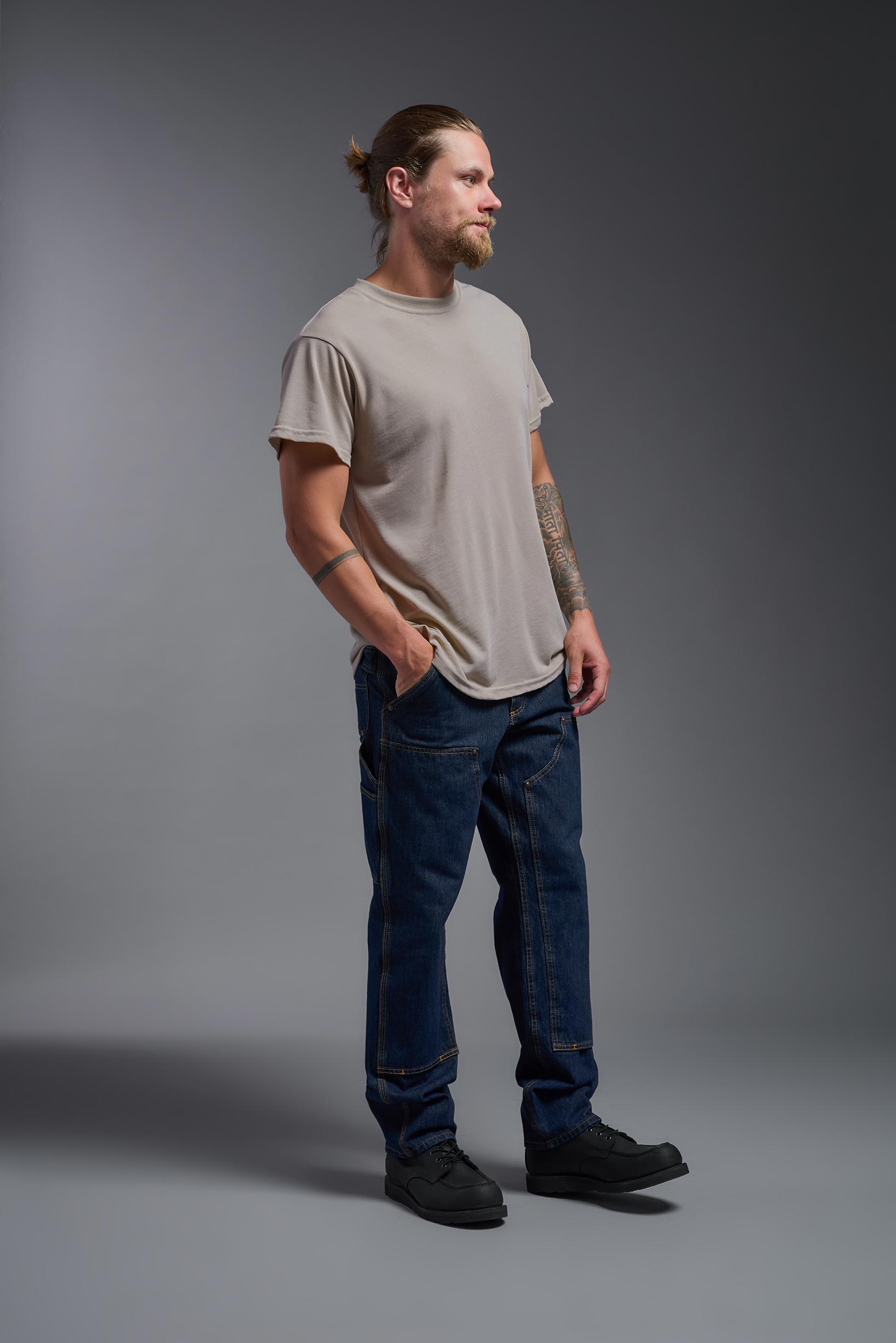 A male model wearing the men's DuroSoft Outdoor Tee in the color desert, made out of 100% filament polyester, showing the modern fit from a side view. This shirt quick-dries, wicks moisture and is made in the USA. #desert