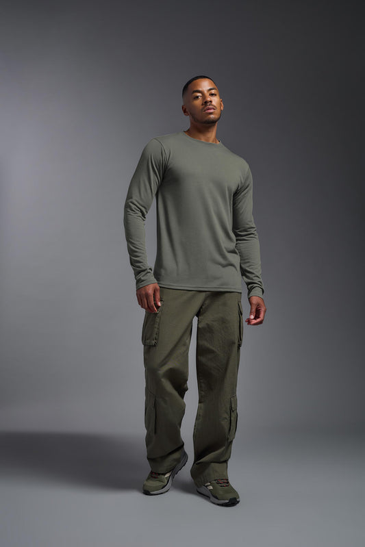 A male model wearing the men's DuroSoft Outdoor Long Sleeve in the color army gray made out of 100% filament polyester, showing the modern fit from a front view. This shirt quick-dries, wicks moisture and is made in the USA. #army-gray