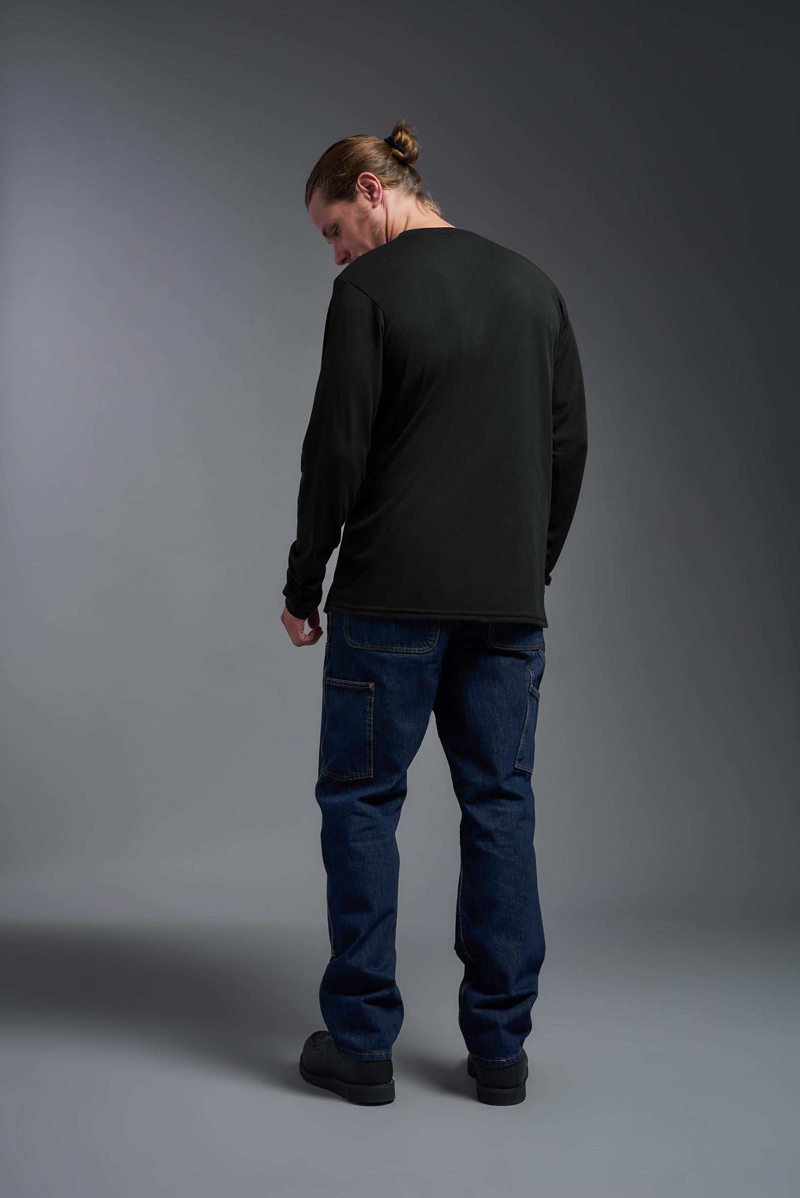 A male model wearing the men's DuroSoft Outdoor Long Sleeve in the color black, made out of 100% filament polyester, showing the modern fit from a back view. This shirt quick-dries, wicks moisture and is made in the USA. #black