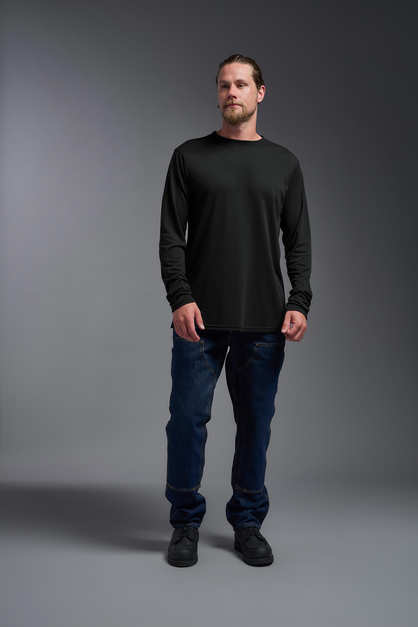 A male model wearing the men's DuroSoft Outdoor Long Sleeve in the color black, made out of 100% filament polyester, showing the modern fit from a front view. This shirt quick-dries, wicks moisture and is made in the USA. #black