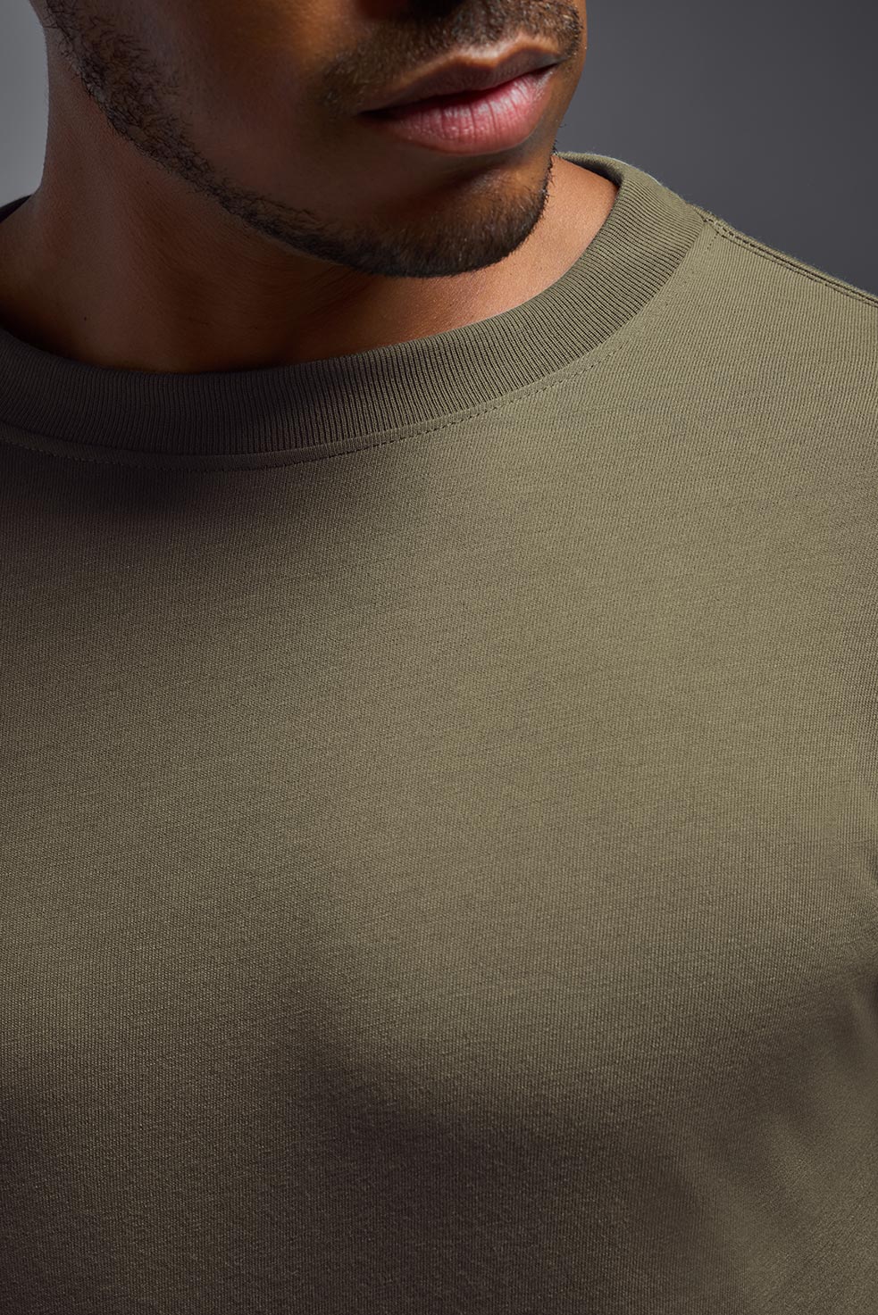 A male model wearing the men's DuroSoft Outdoor Long Sleeve in the color tan-499 made out of 100% filament polyester, showing the modern fit from a closeup collar view. This shirt quick-dries, wicks moisture and is made in the USA. #tan-499