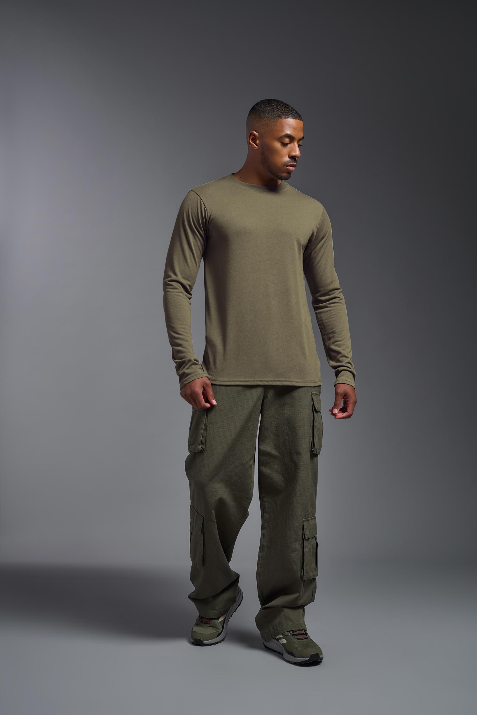 A male model wearing the men's DuroSoft Outdoor Long Sleeve in the color tan-499 made out of 100% filament polyester, showing the modern fit from a front view. This shirt quick-dries, wicks moisture and is made in the USA. #tan-499