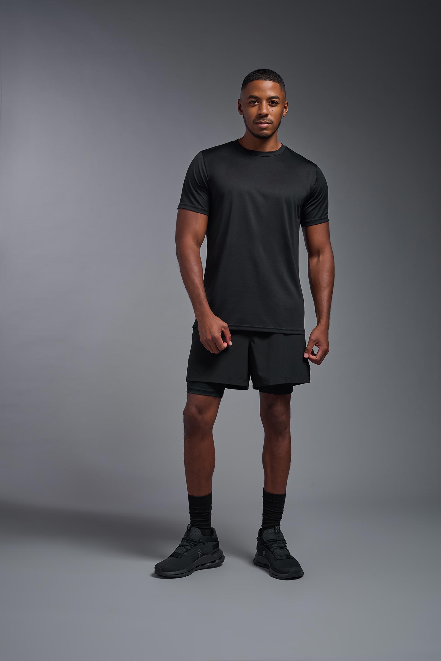 A male model wearing the men's EcoTek™ Recycled Performance Tee in the color black, made out of 100% recycled polyester REPREVE®, showing the modern fit from a front view. This shirt features a mechanical stretch, quick-dries, wicks moisture and is made in the USA. #black