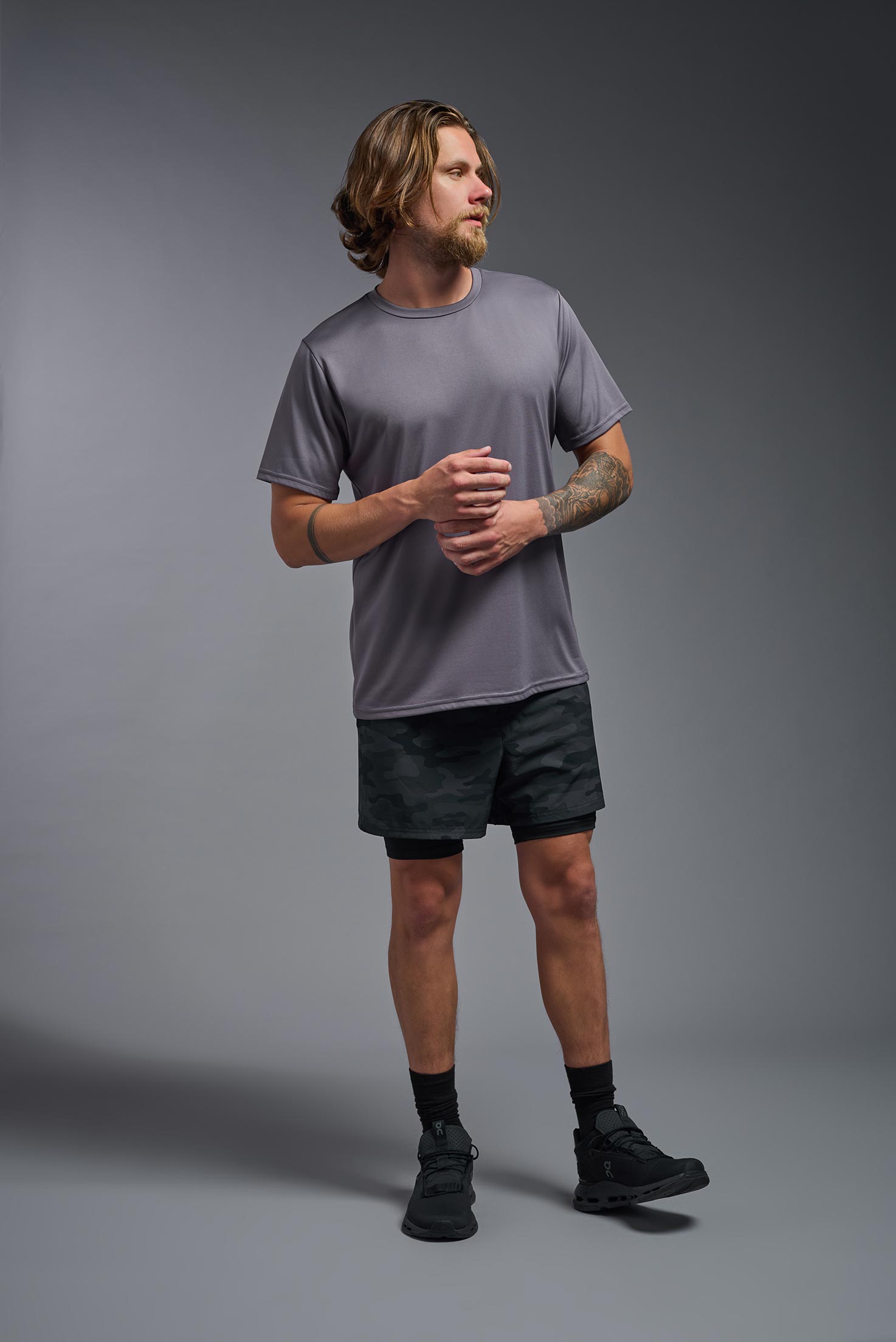 A male model wearing the men's EcoTek™ Recycled Performance Tee in the color charcoal, made out of 100% recycled polyester REPREVE®, showing the modern fit from a front view. This shirt features a mechanical stretch, quick-dries, wicks moisture and is made in the USA. #charcoal