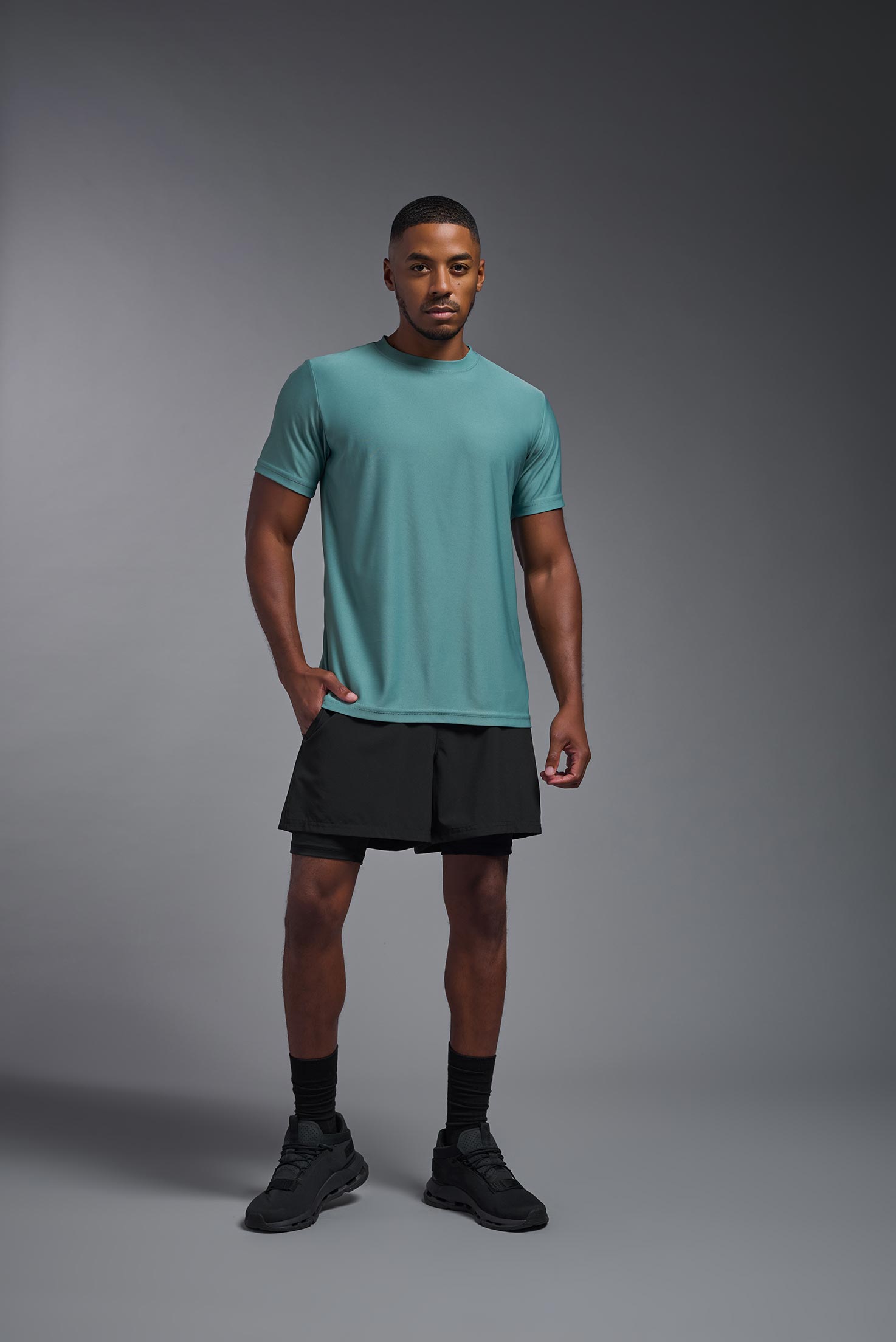 A male model wearing the men's EcoTek™ Recycled Performance Tee in the color juniper, made out of 100% recycled polyester REPREVE®, showing the modern fit from a front view. This shirt features a mechanical stretch, quick-dries, wicks moisture and is made in the USA. #juniper