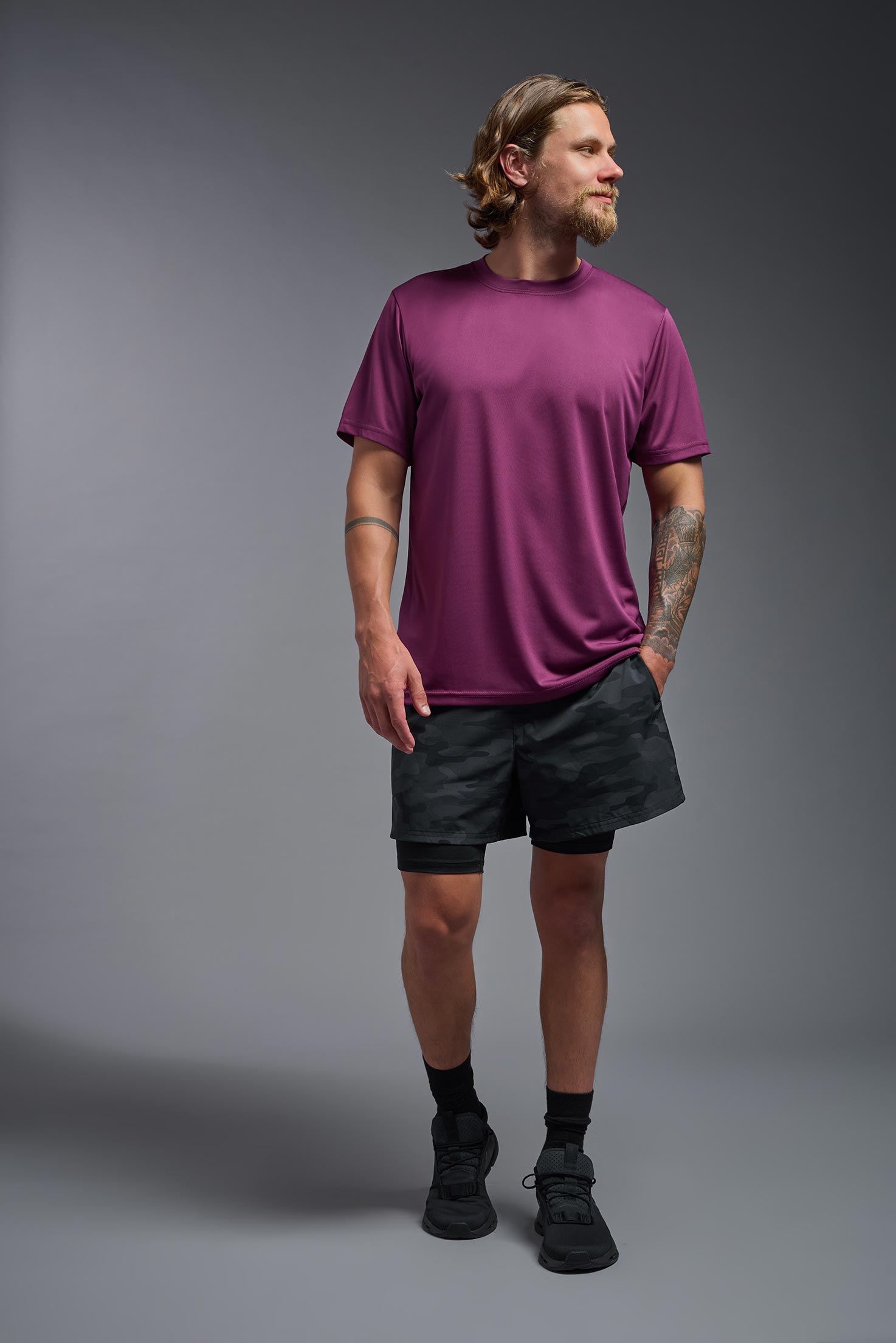 A male model wearing the men's EcoTek™ Recycled Performance Tee in the color merlot, made out of 100% recycled polyester REPREVE®, showing the modern fit from a front view. This shirt features a mechanical stretch, quick-dries, wicks moisture and is made in the USA. #merlot