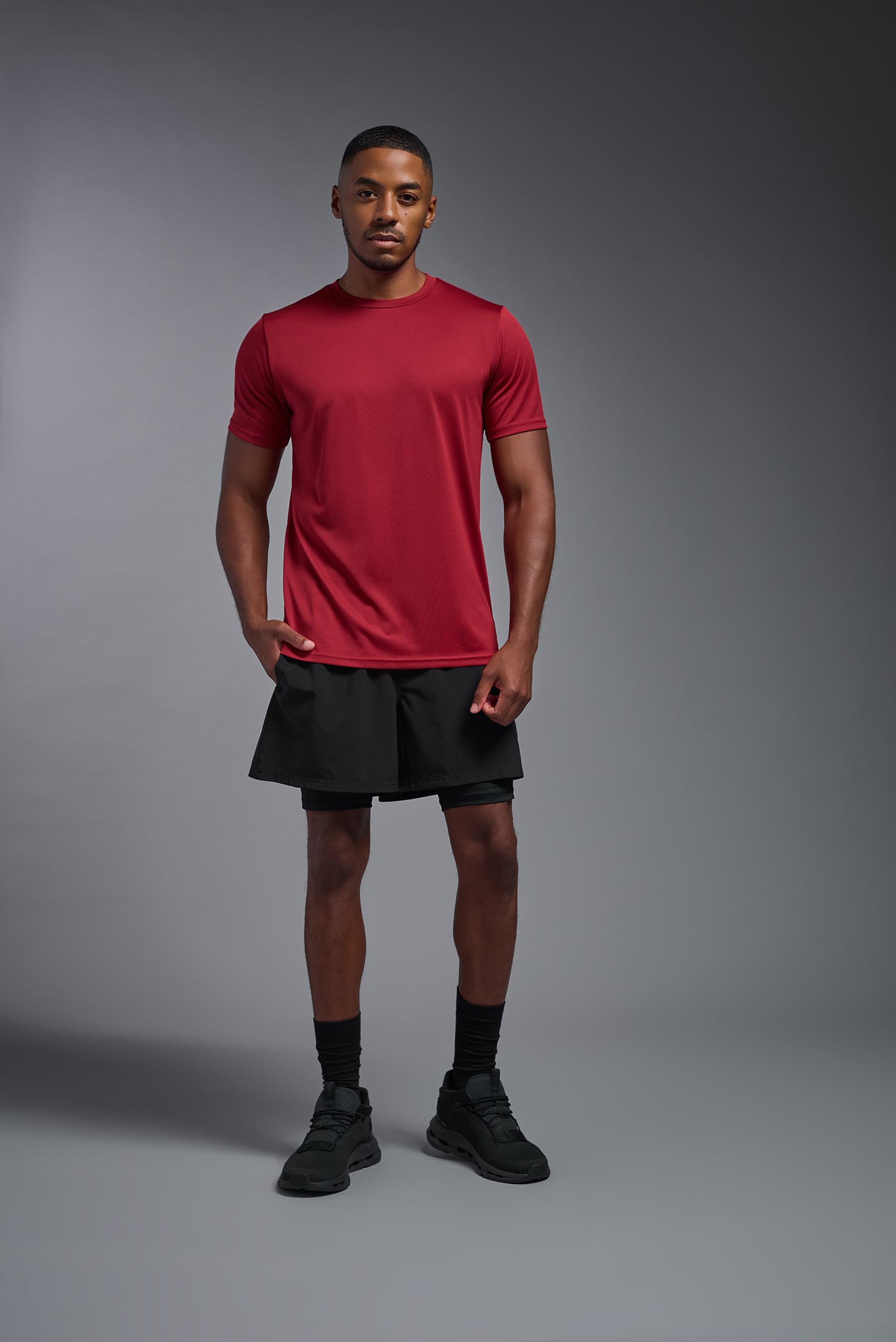 A male model wearing the men's EcoTek™ Recycled Performance Tee in the color poinsettia, made out of 100% recycled polyester REPREVE®, showing the modern fit from a front view. This shirt features a mechanical stretch, quick-dries, wicks moisture and is made in the USA. #poinsettia