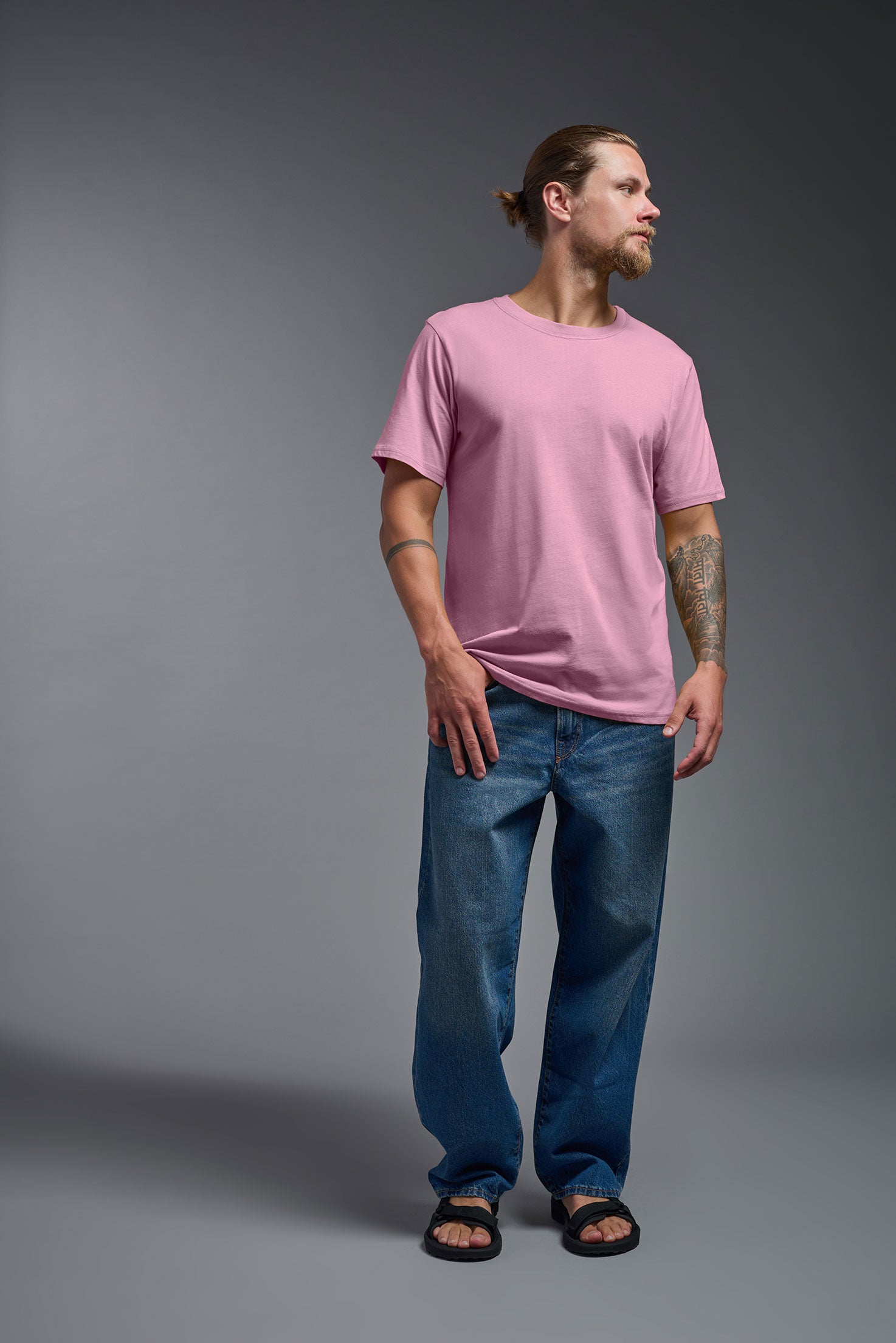 A male model wearing the unisex Organic Soft Cotton T-shirt in the color Himalayan salt pink, made in the USA from 100% GOTS certified organic cotton from a front view. This shirt is unisex, made in the USA, and perfect for bulk screen printing and decorating. #himalayan-salt