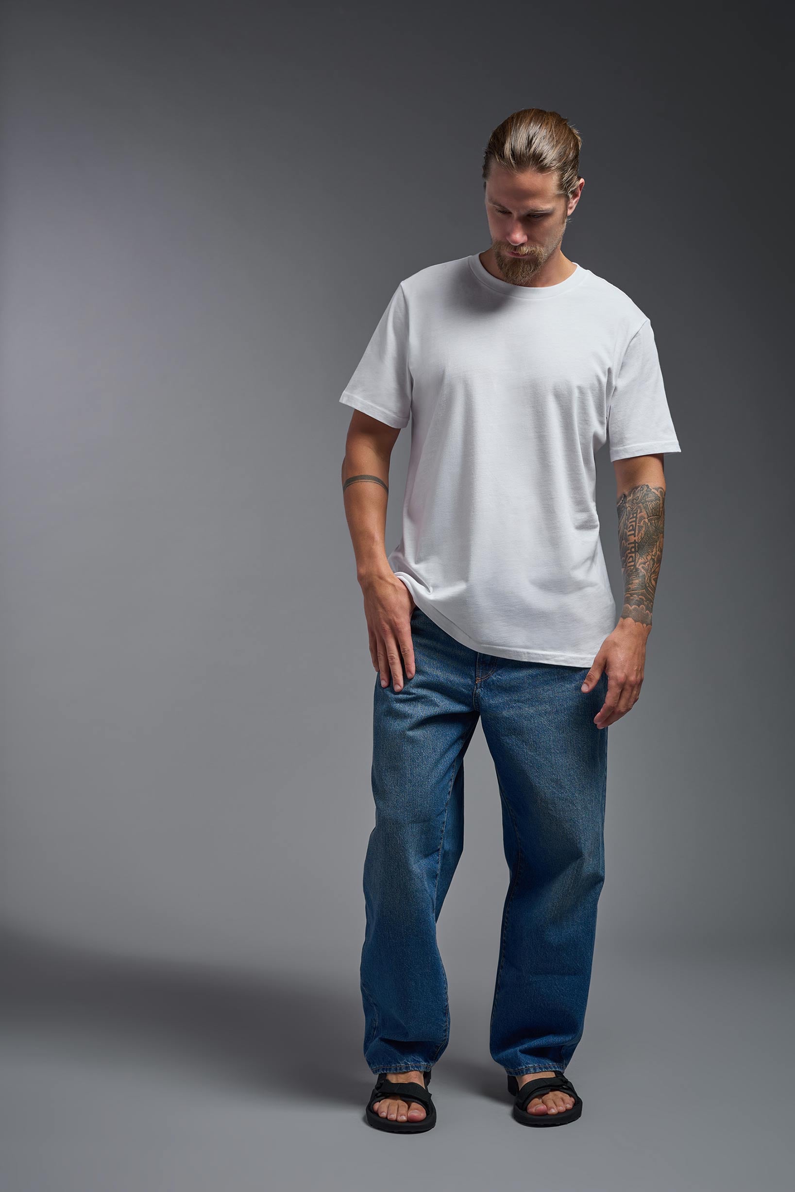 A male model wearing the unisex Organic Soft Cotton T-shirt in the color white, made in the USA from 100% GOTS certified organic cotton from a front view. #white