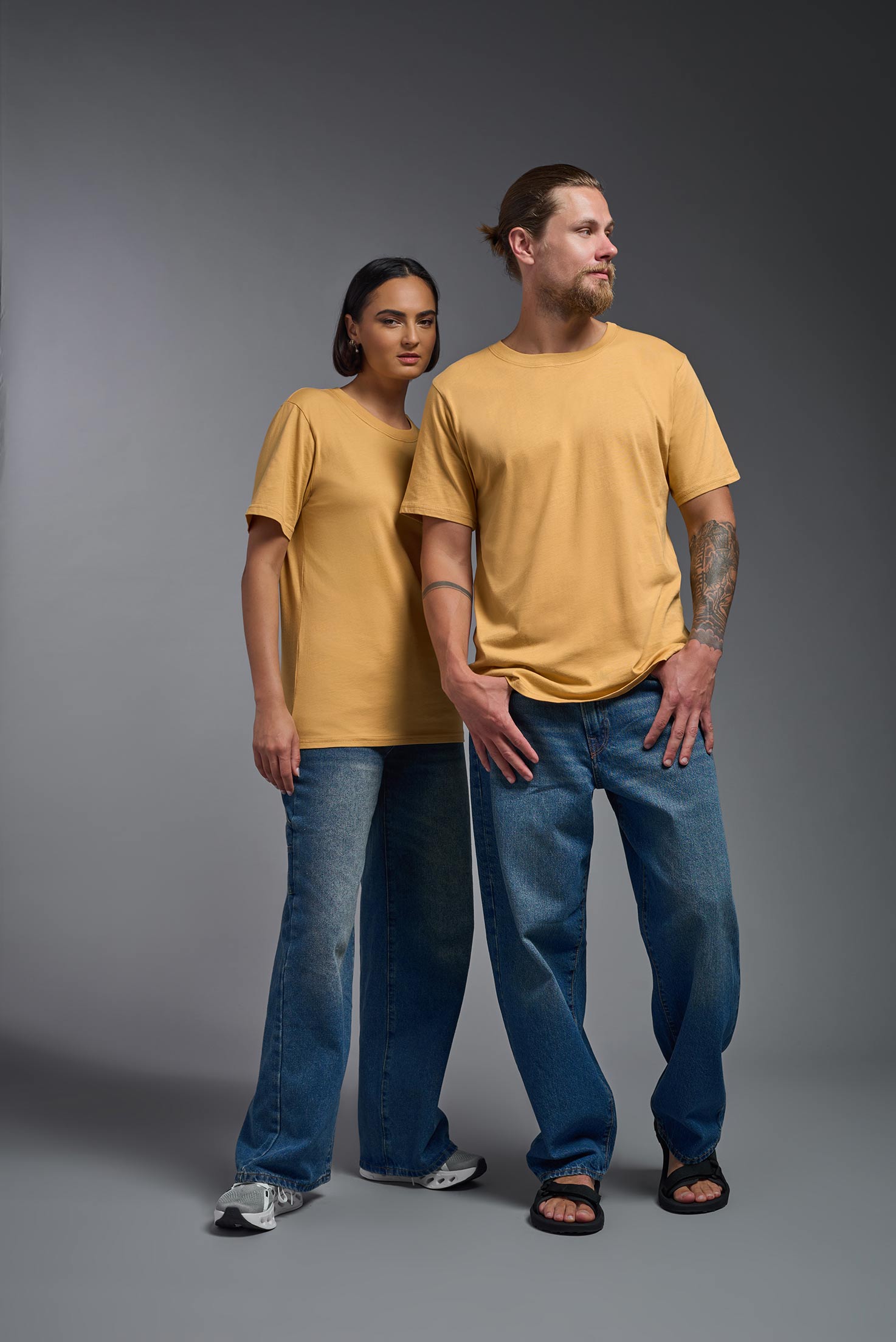 A male and female model wearing the unisex Organic Soft Cotton T-shirt in the color harvest, made in the USA from 100% GOTS certified organic cotton from a front view. This shirt is unisex, made in the USA, and perfect for bulk screen printing and decorating. #harvest