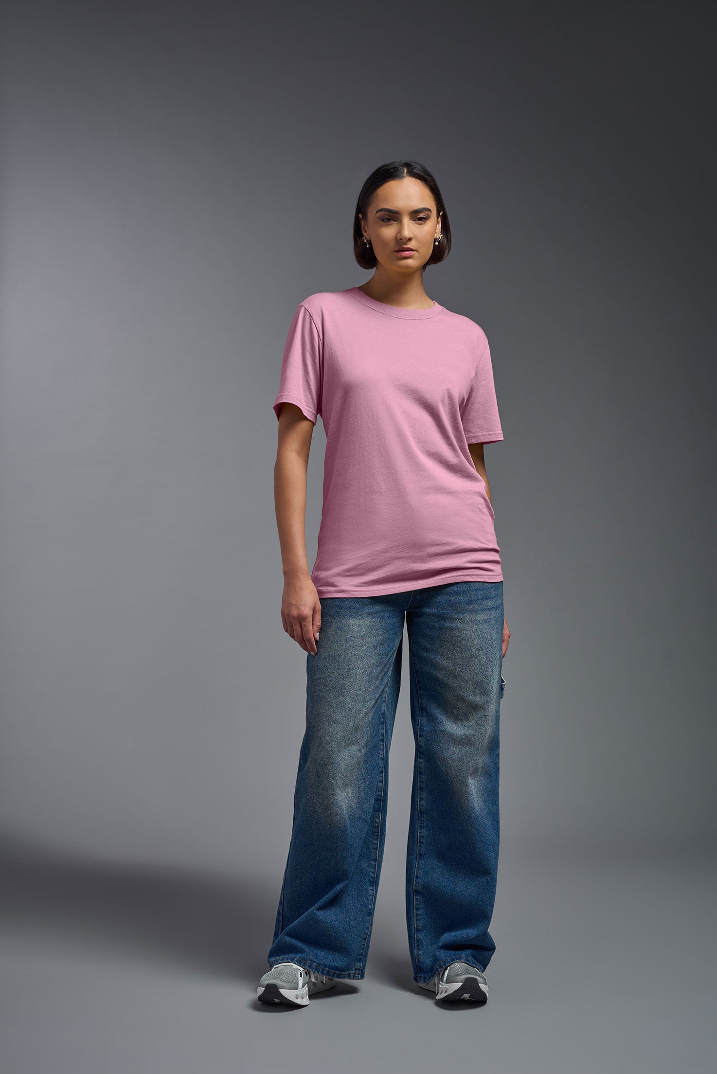 A female model wearing the unisex Organic Soft Cotton T-shirt in the color Himalayan salt pink, made in the USA from 100% GOTS certified organic cotton from a front view. This shirt is unisex, made in the USA, and perfect for bulk screen printing and decorating. #himalayan-salt