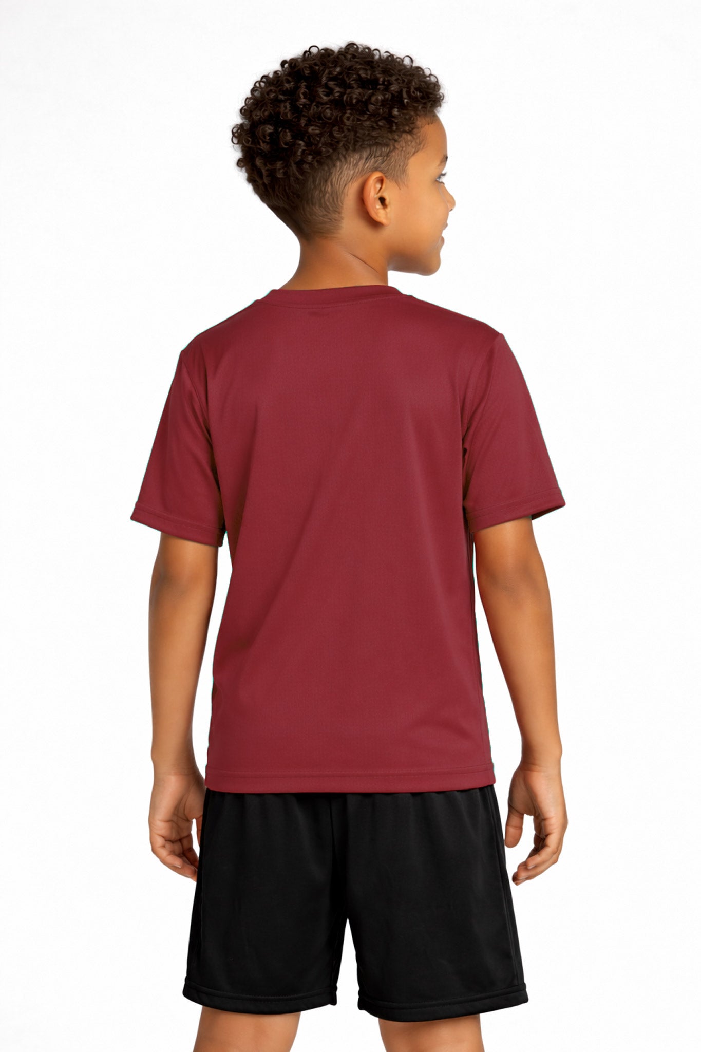 A youth model wearing the youth DriMax Crewneck Expert Tee in the color cardinal, made out of 100% polyester, showing the relaxed fit from a back view. This shirt wicks sweat, quick-dries, and eliminates odors for up to 30 UV protection. Made in the USA. #cardinal