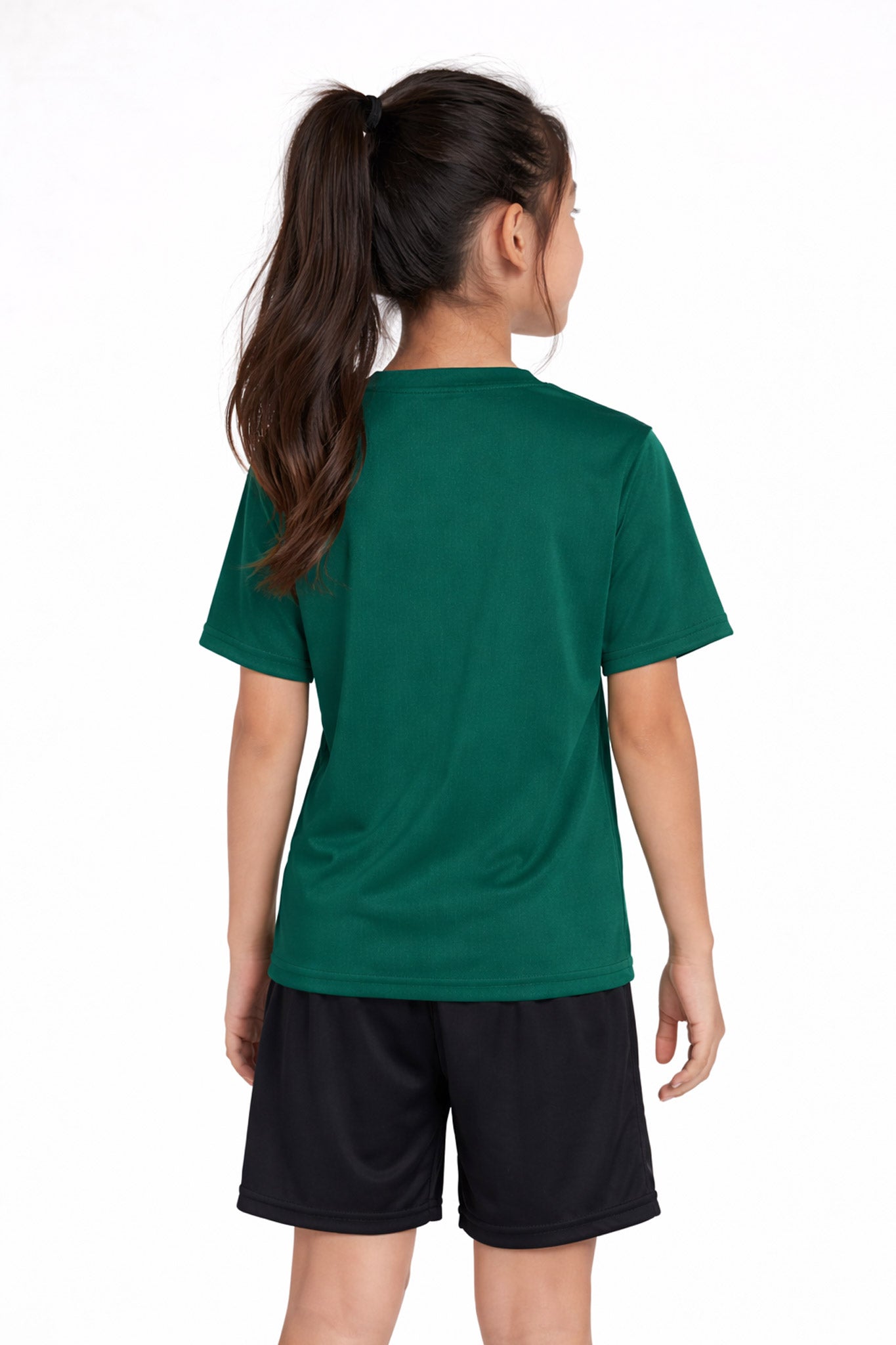 A youth model wearing the youth DriMax Crewneck Expert Tee in the color forest green, made out of 100% polyester, showing the relaxed fit from a black view. This shirt wicks sweat, quick-dries, and eliminates odors for up to 30 UV protection. Made in the USA. #forest