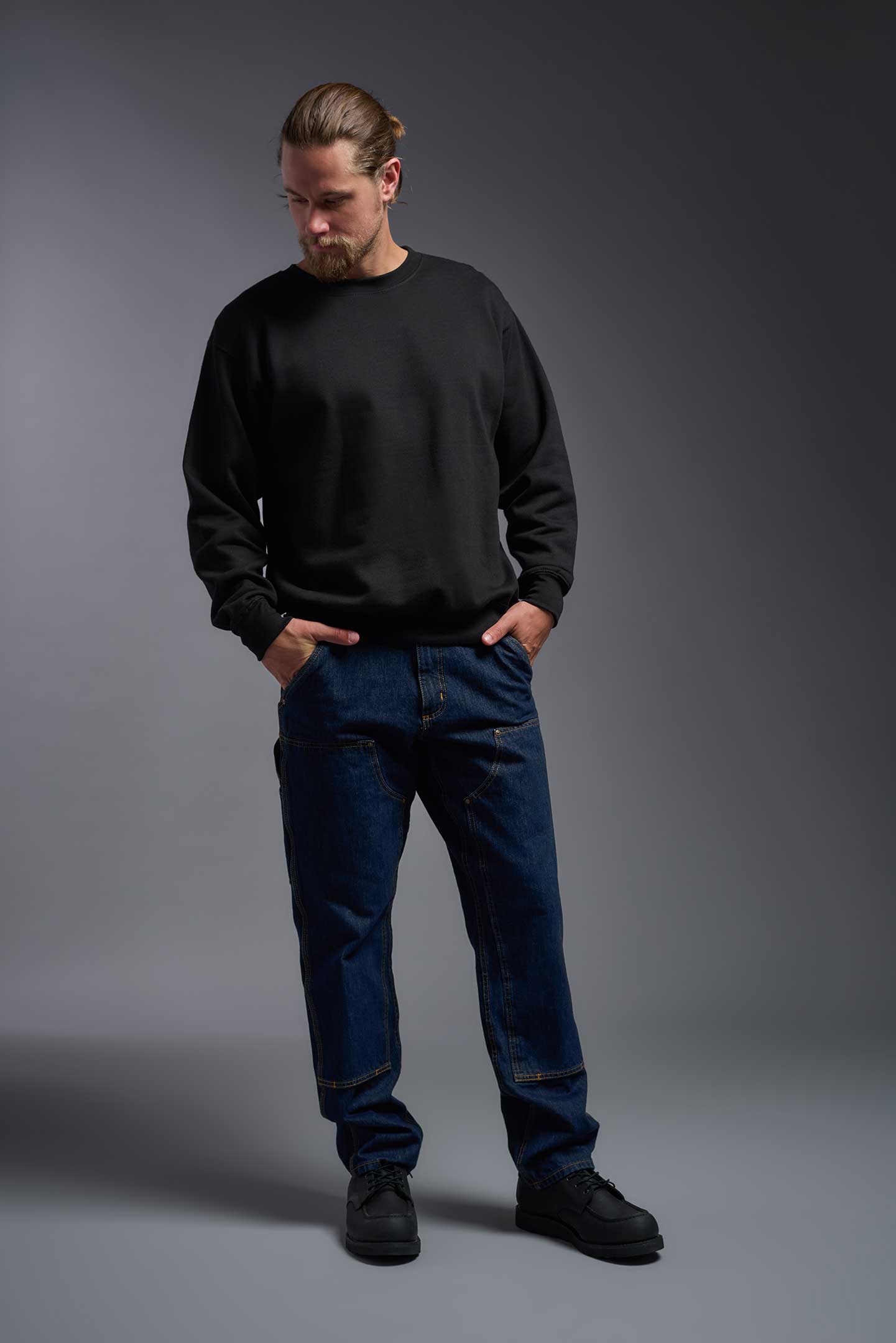 A male model wearing the unisex Americana 3-End Fleece Crewneck Sweatshirt in the color black, made from 75% combed ring-spun USA-grown cotton and 25% polyester, showing the relaxed fit from a front view. This premium fleece hoodie is Made in the USA. #black