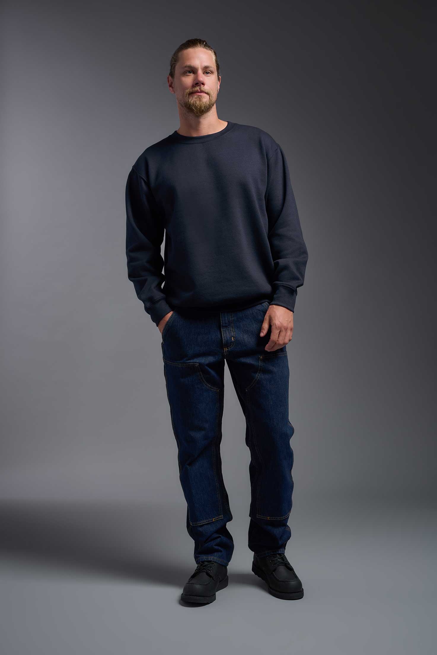 A male model wearing the unisex Americana 3-End Fleece Crewneck Sweatshirt in the color navy, made from 75% combed ring-spun USA-grown cotton and 25% polyester, showing the relaxed fit from a front view. This premium fleece hoodie is Made in the USA. #navy