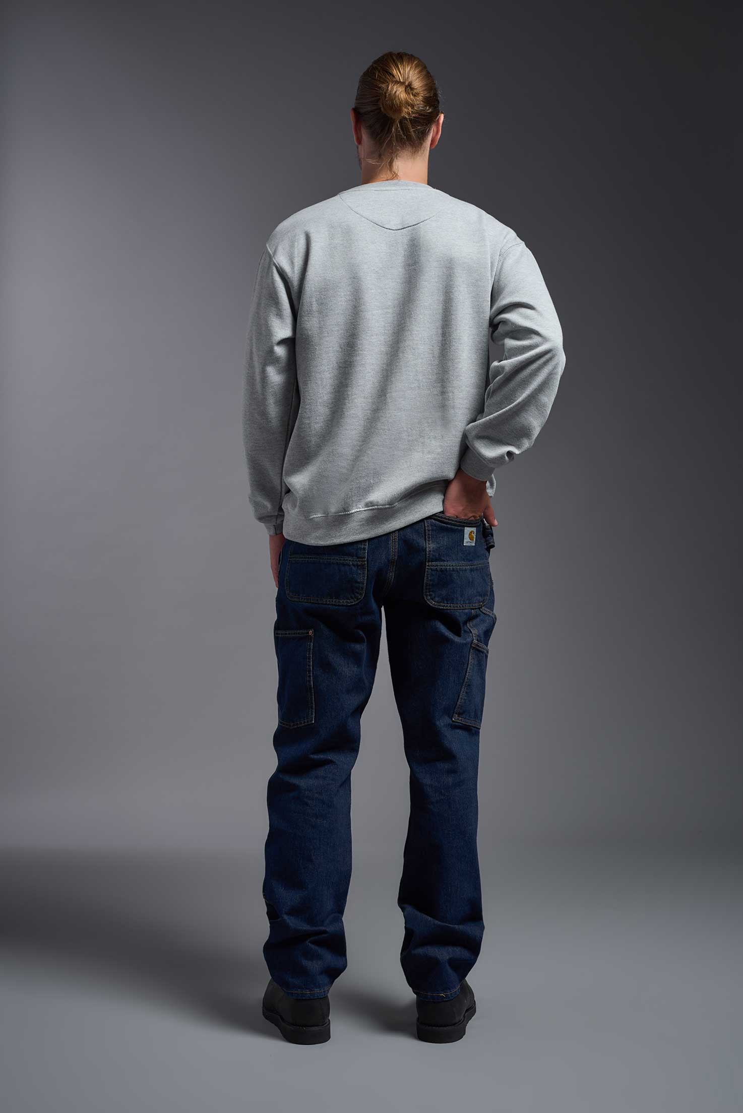 A male model wearing the unisex Americana 3-End Fleece Crewneck Sweatshirt in the color sport gray, made from 75% combed ring-spun USA-grown cotton and 25% polyester, showing the relaxed fit from a back view. This premium fleece hoodie is Made in the USA. #sport-gray
