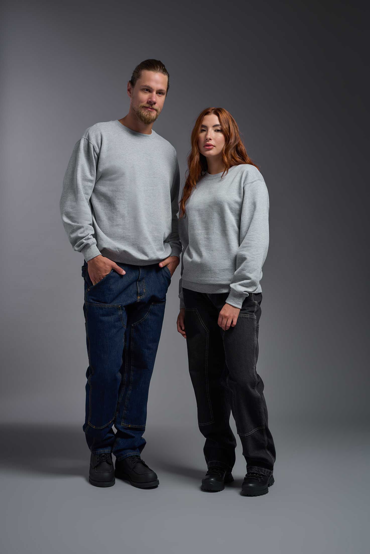 A male and female model wearing the unisex Americana 3-End Fleece Crewneck Sweatshirt in the color sport gray, made from 75% combed ring-spun USA-grown cotton and 25% polyester, showing the relaxed fit from a front view. This premium fleece hoodie is Made in the USA. #sport-gray