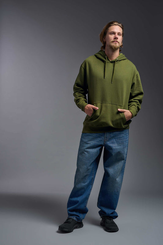 A male model wearing the unisex Americana 3-End Fleece Pullover Hoodie in the color military green, made from 75% combed ring-spun USA-grown cotton and 25% polyester, showing the relaxed fit from a front view. This premium fleece hoodie is Made in the USA. #military-green