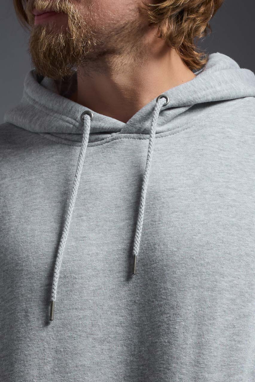 A male model wearing the unisex Americana 3-End Fleece Pullover Hoodie in the color sport gray, made from 75% combed ring-spun USA-grown cotton and 25% polyester, showing the relaxed fit from a close-up collar view. This premium fleece hoodie is Made in the USA. #sport-gray