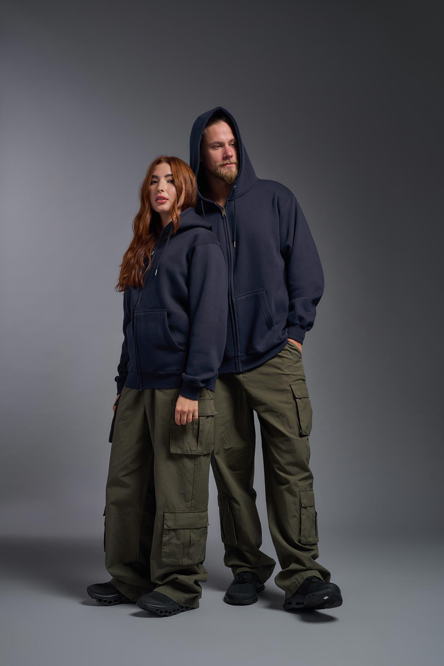 A male and female model wearing the unisex Americana 3-End Fleece Full Zip Hoodie in the color navy, made from 75% combed ring-spun USA-grown cotton and 25% polyester, showing the relaxed fit from a front view. This premium fleece hoodie is Made in the USA. #navy