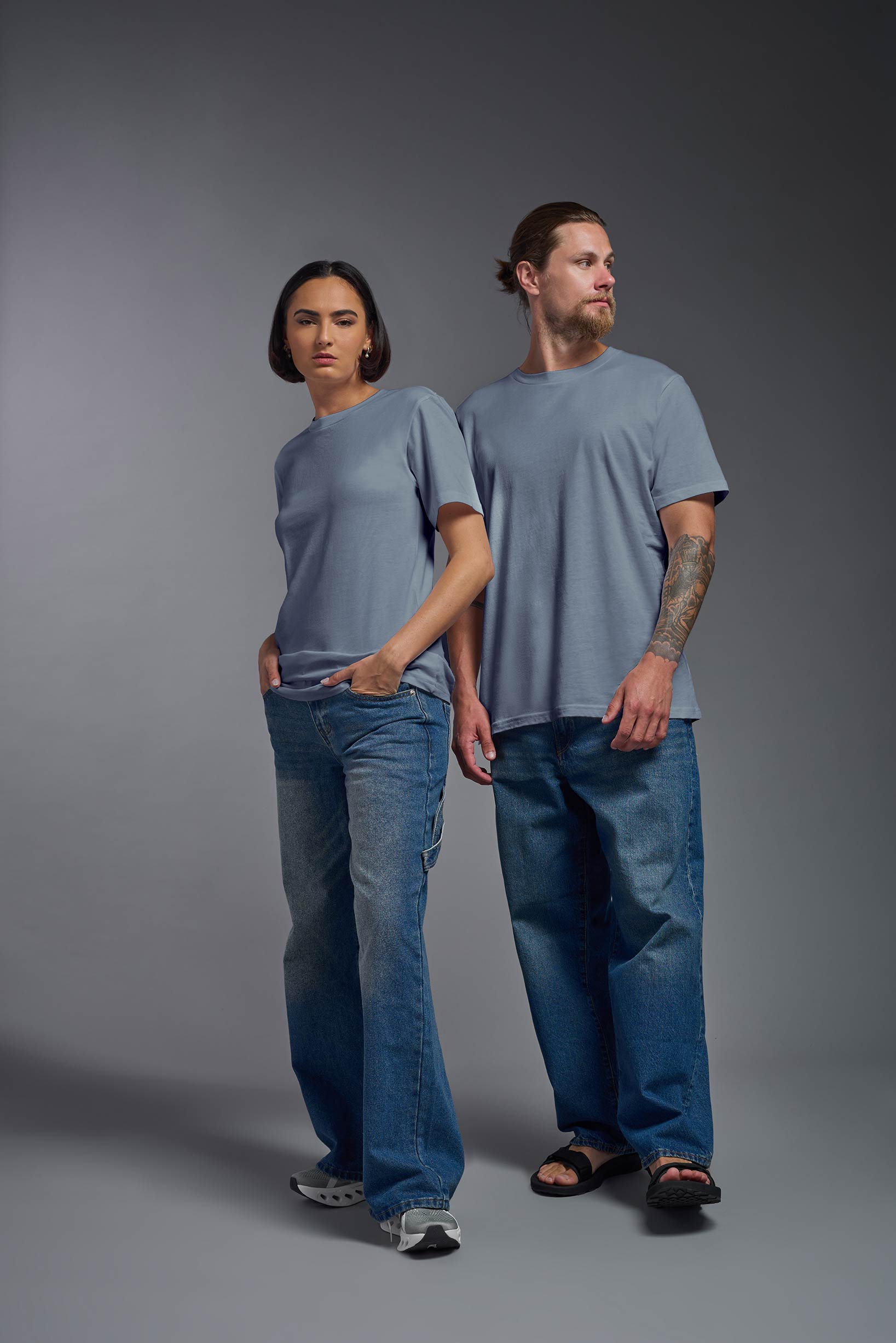 A female and male model wearing the unisex Organic Soft Cotton T-shirt in the color canyon blue, made in the USA from 100% GOTS certified organic cotton from a front view. This shirt is unisex, made in the USA, and perfect for bulk screen printing and decorating. #canyon-blue