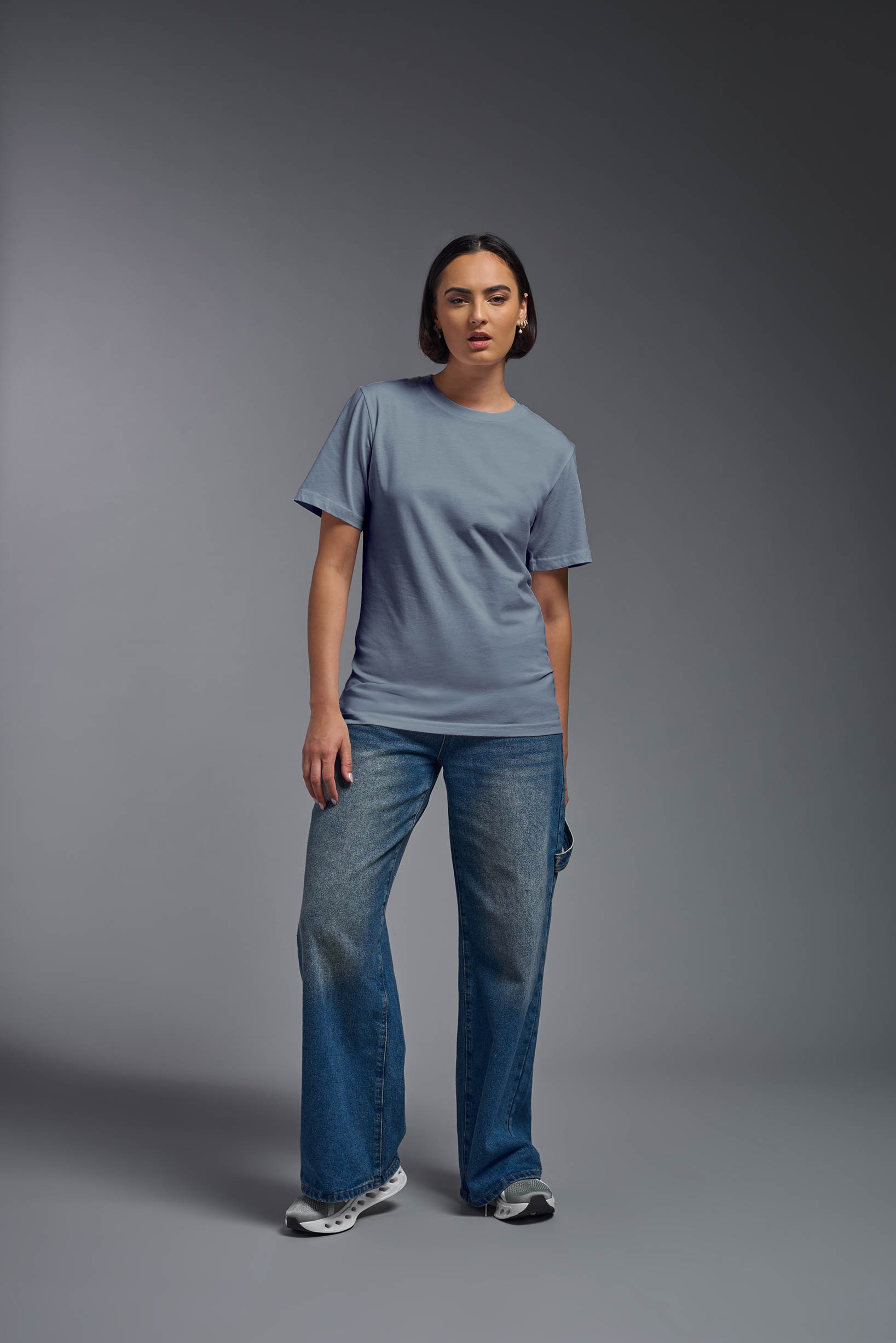 A female model wearing the unisex Organic Soft Cotton T-shirt in the color canyon blue, made in the USA from 100% GOTS certified organic cotton from a closeup collar front view. This shirt is unisex, made in the USA, and perfect for bulk screen printing and decorating. #canyon-blue